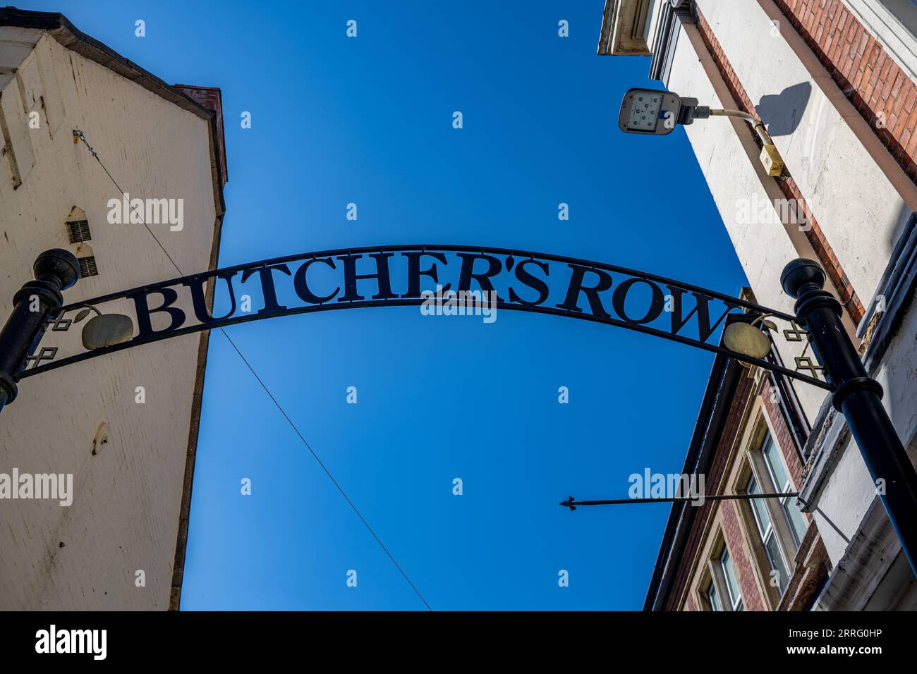 Butchers Row Grantham Lincolnshire – Ein traditionelles Metallschild über dem Kopf, wenn Sie die Straße vor einem blauen Sommerhimmel betreten Stockfoto