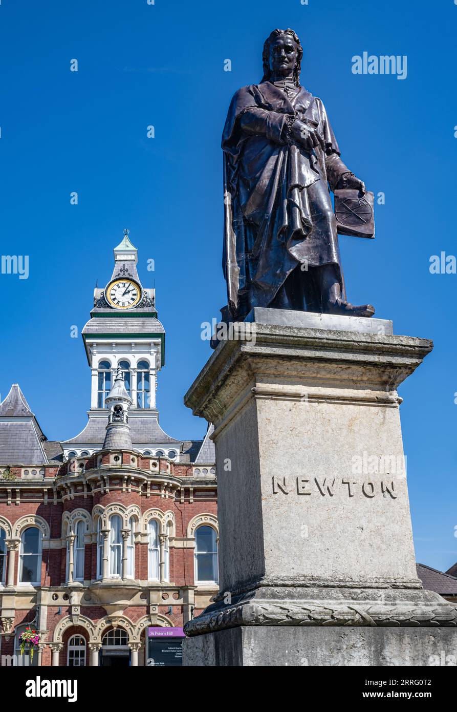 St Peters Hill Grantham Lincolnshire – Statue von Sir Isaac Newton, der in der Stadt zur Schule ging, vor einem Sommerhimmel mit der Town Guildhall im Hintergrund Stockfoto