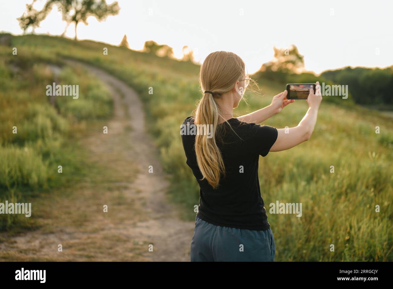 Frau auf dem Spaziergang hält an, um ein Video von der Naturlandschaft zu machen Stockfoto