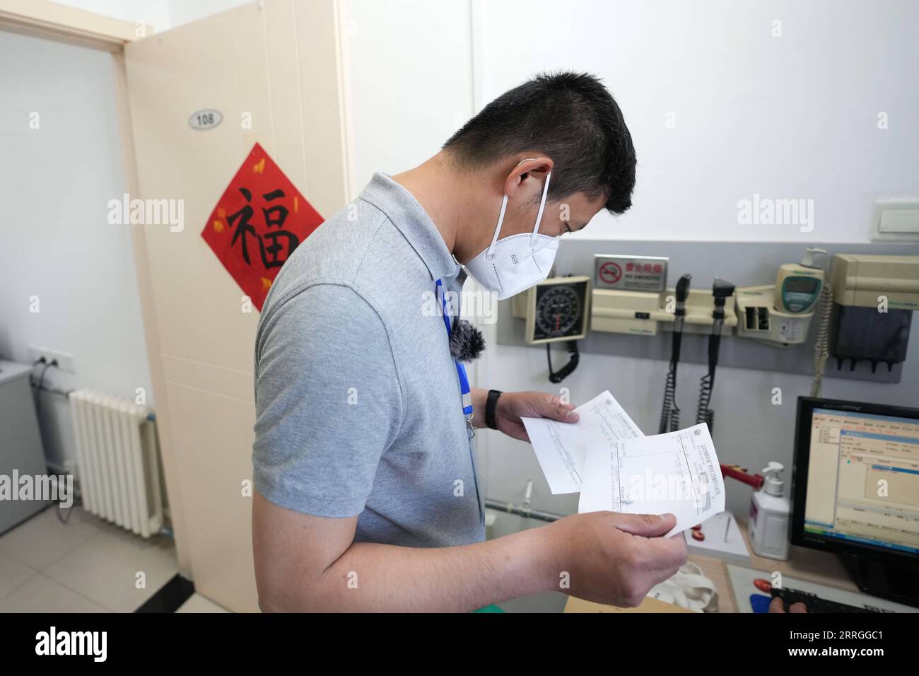 220522 -- PEKING, 22. Mai 2022 -- Mei Xiaodong überprüft die medizinischen Rezepte für Bewohner unter Hausquarantäne im Bezirk Chaoyang in Peking, Hauptstadt von China, 21. Mai 2022. Mei Xiaodong, 35, ist ein Regierungsangestellter im Bezirk Chaoyang in Peking. Mei wurde entsandt, um sich der Arbeit der Mitarbeiter an vorderster Front in einer Gemeinde im Kampf gegen COVID-19 anzuschließen und den unter häuslicher Quarantäne stehenden Bewohnern beim Kauf von Medikamenten gegen chronische Krankheiten zu helfen. Mitarbeiter in der Gemeinschaft, Ärzte und Freiwillige tragen die Verantwortung für die Beurteilung, den Kauf und die Lieferung von Medikamenten, die von Anwohnern über WeChat oder telefonische Anrufe bestellt werden Stockfoto