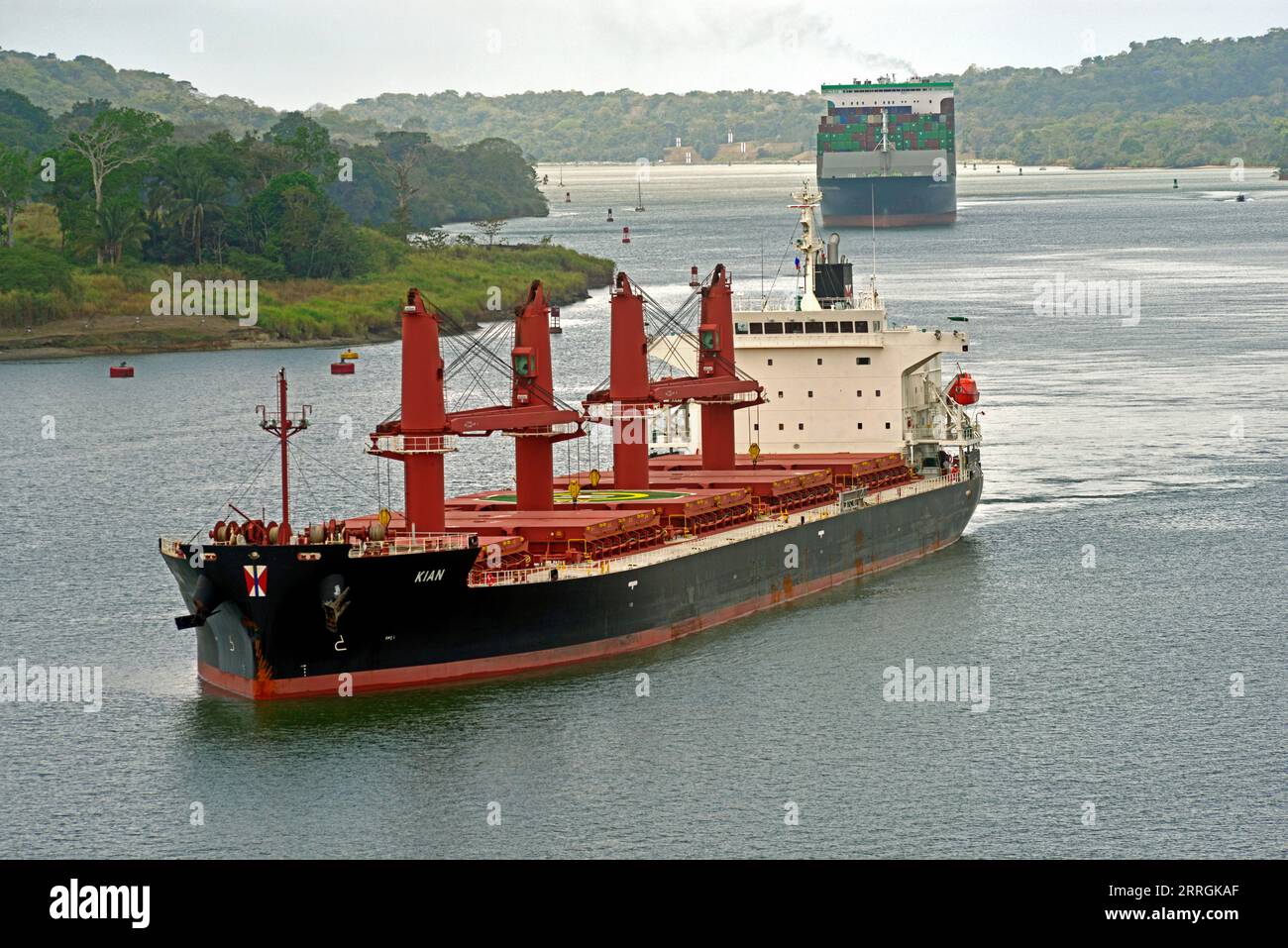 Der Bulk Carrier Kian wird auf dem Gatun Lake gesehen, während er den Panamakanal von West nach Ost durchquert. Der Container Ship Ever Forward wird verfolgt. Stockfoto