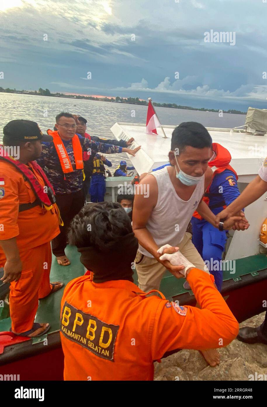 220529 -- BANJARMASIN, 29. Mai 2022 -- das am 29. Mai 2022 aufgenommene Handy-Foto zeigt Rettungskräfte, die einen Überlebenden im Hafen von Trisakti in Banjarmasin, Süd-Kalimantan, Indonesien, halten. Die Rettungskräfte setzten einen Hubschrauber und mehrere Schiffe mit mehr als 100 Menschen in einer Such- und Rettungsaktion für 25 vermisste Menschen ein, nachdem ein Schiff vor der Provinz South Sulawesi in Indonesien im Wasser versunken war, sagte ein Rettungsmann am Sonntag. Foto von /Xinhua INDONESIA-SOUTH KALIMANTAN-BANJARMASIN-SOUTH SULAWESI-SHIP-CAPSIZING-RESCUE BahaudinxQusairi PUBLICATIONxNOTxINxCHN Stockfoto
