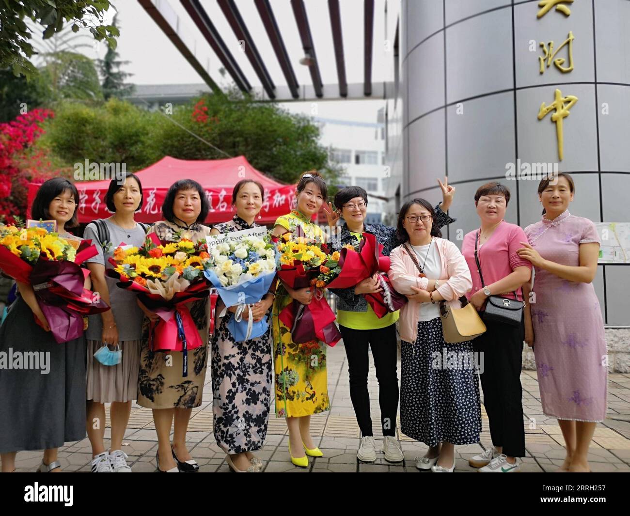 220609 -- KUNMING, 9. Juni 2022 -- Eltern posieren für ein Gruppenfoto an einem Prüfungsort der nationalen Hochschuleintrittsprüfung in Kunming, Südwestchinas Provinz Yunnan, 8. Juni 2022. UM MIT China Fokus ZU GEHEN: Klassische Kleidung gibt Gaokao Prüfung Kandidaten einen Boost CHINA-YUNNAN-COLLEGE EINGANG EXAM-QIPAO CN Xinhua PUBLICATIONxNOTxINxCHN Stockfoto