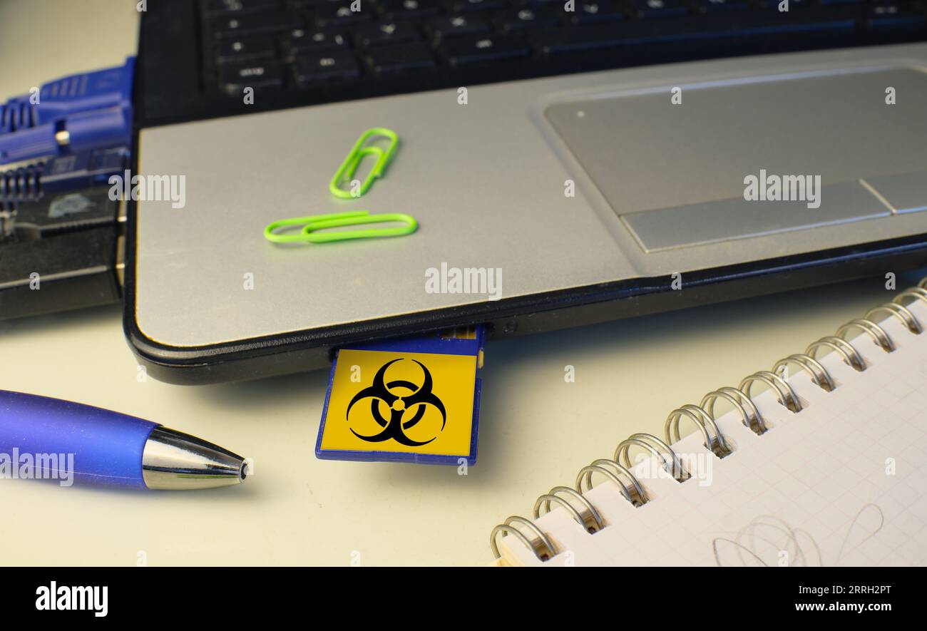 Infektion eines Laptops mit einem Computervirus über eine Speicherkarte, Computervirenangriff, Hacking, Malware, Computerkriminalität Konzept. Stockfoto