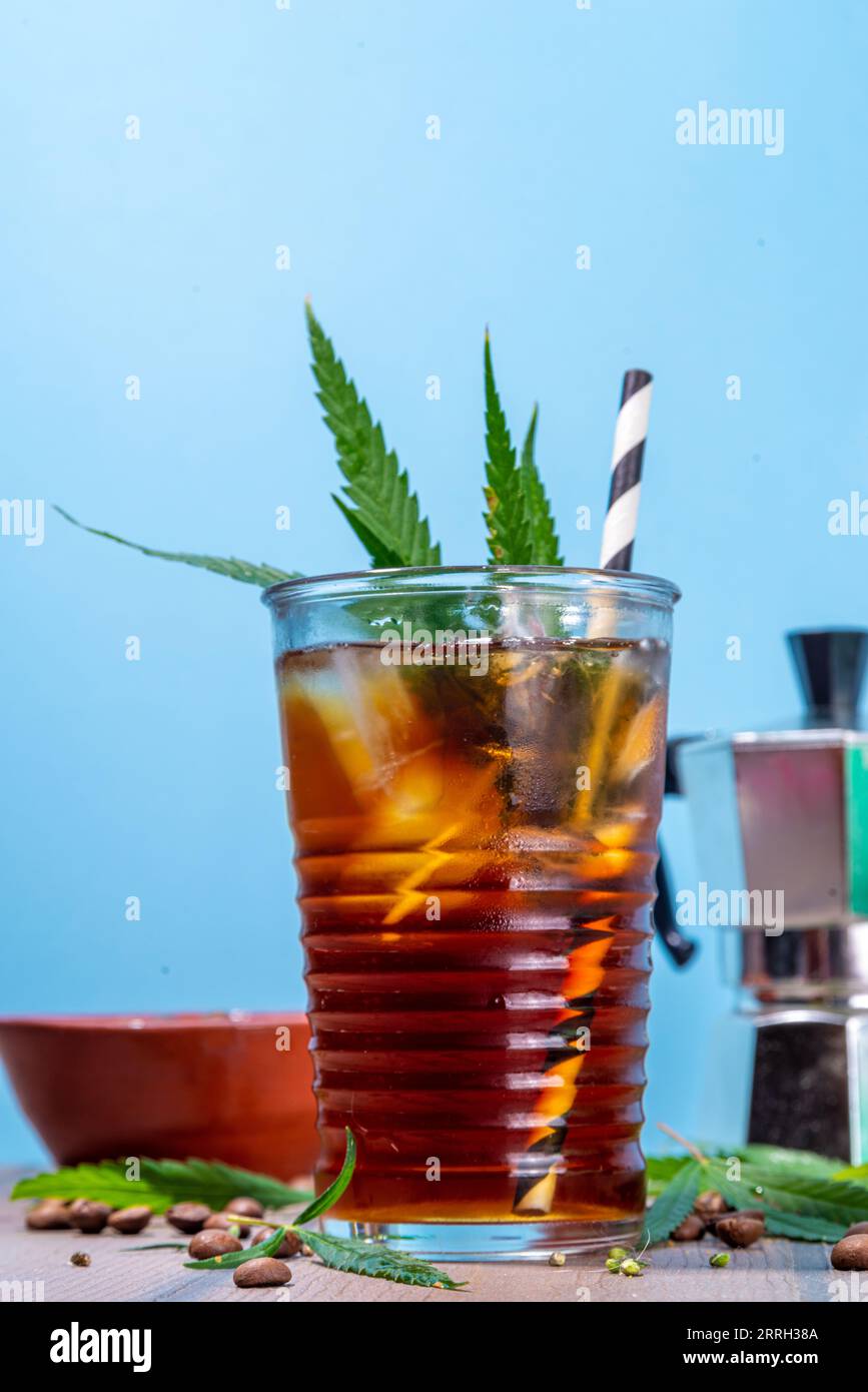 Medizinisches Cannabis Hanf Kaltkaffeetränk. Glas geeister Espresso-Kaffee mit Cannabisöltropfen und Blattanzug , mit Hanfblättern und Kaffeebohnen, Stockfoto