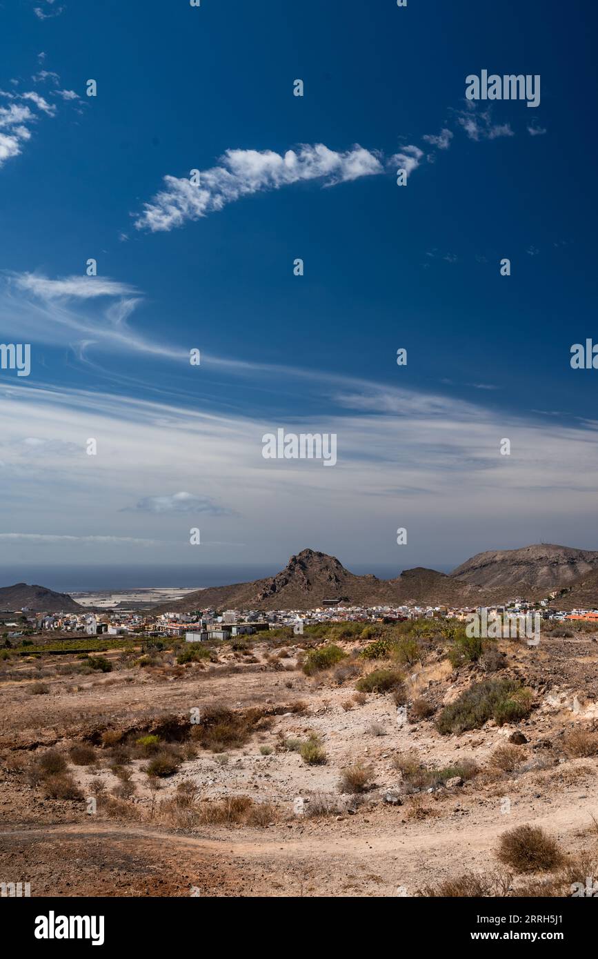 Wanderweg in einer Wüste mit Blick auf eine Stadt, das Meer oder das Meer und die Berge Stockfoto