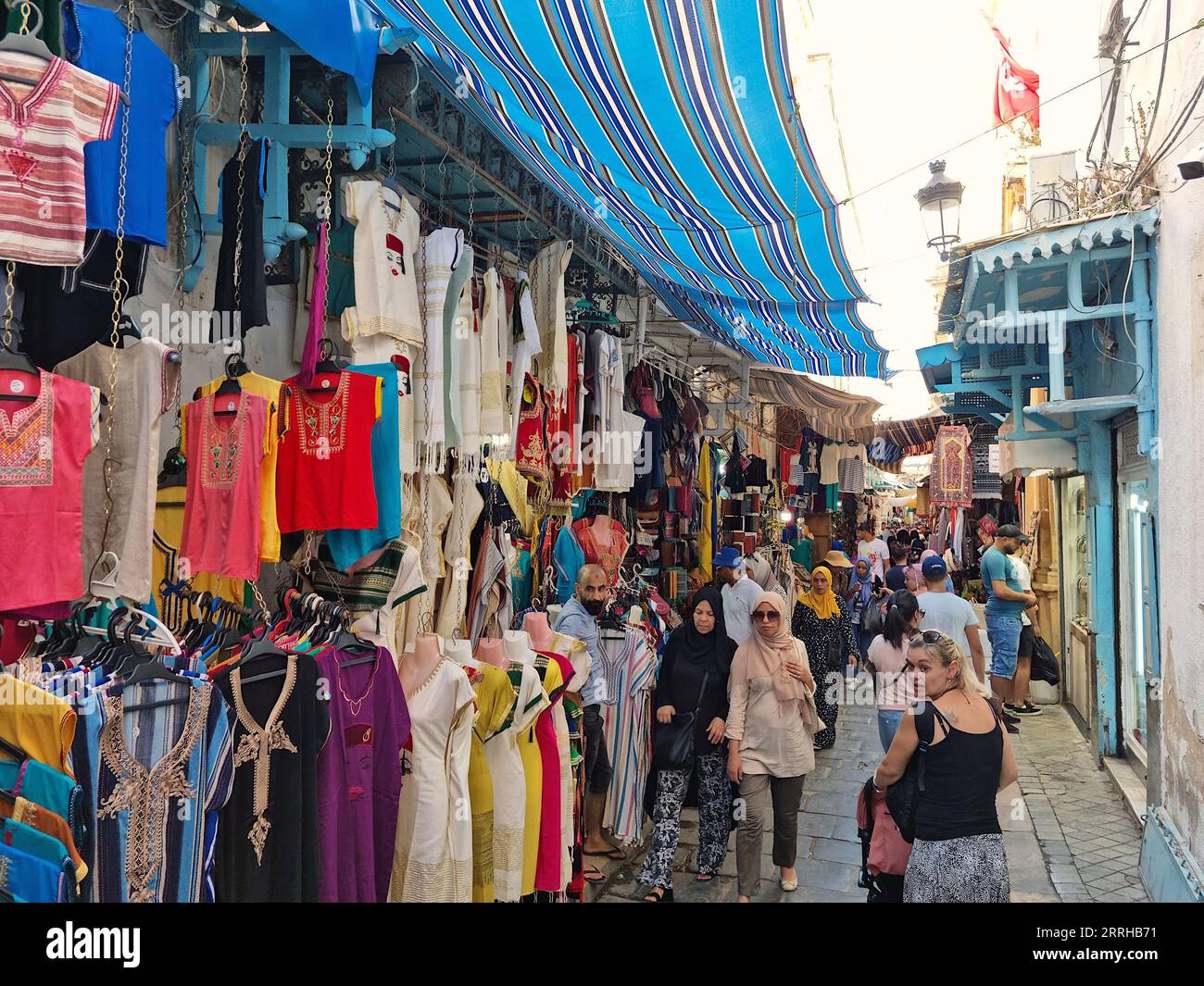 Tunis, Tunesien - 27. August 2022: Menschen, die in der Medina spazieren. Die Medina enthält etwa 700 Denkmäler, darunter Paläste, Moscheen und Mausoleen Stockfoto