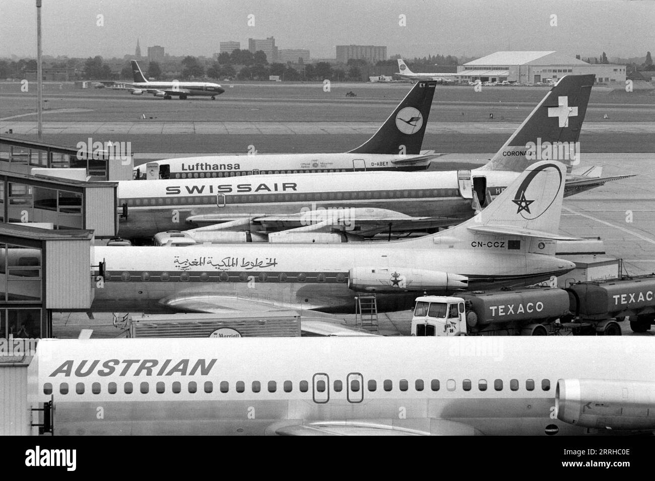 Passagierflugzeuge von Lufthansa, Swissair, Royal Air Maroc und Austrian Airlines parkten am Flughafen Heathrow, London, England, UK 1971. BOAC- und Pan am-Flugzeuge in der Entfernung. Stockfoto