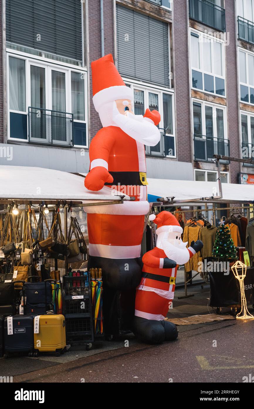 Zwei aufblasbare Santa Clauses winken mitten auf dem Straßenmarkt in Amsterdam Stockfoto