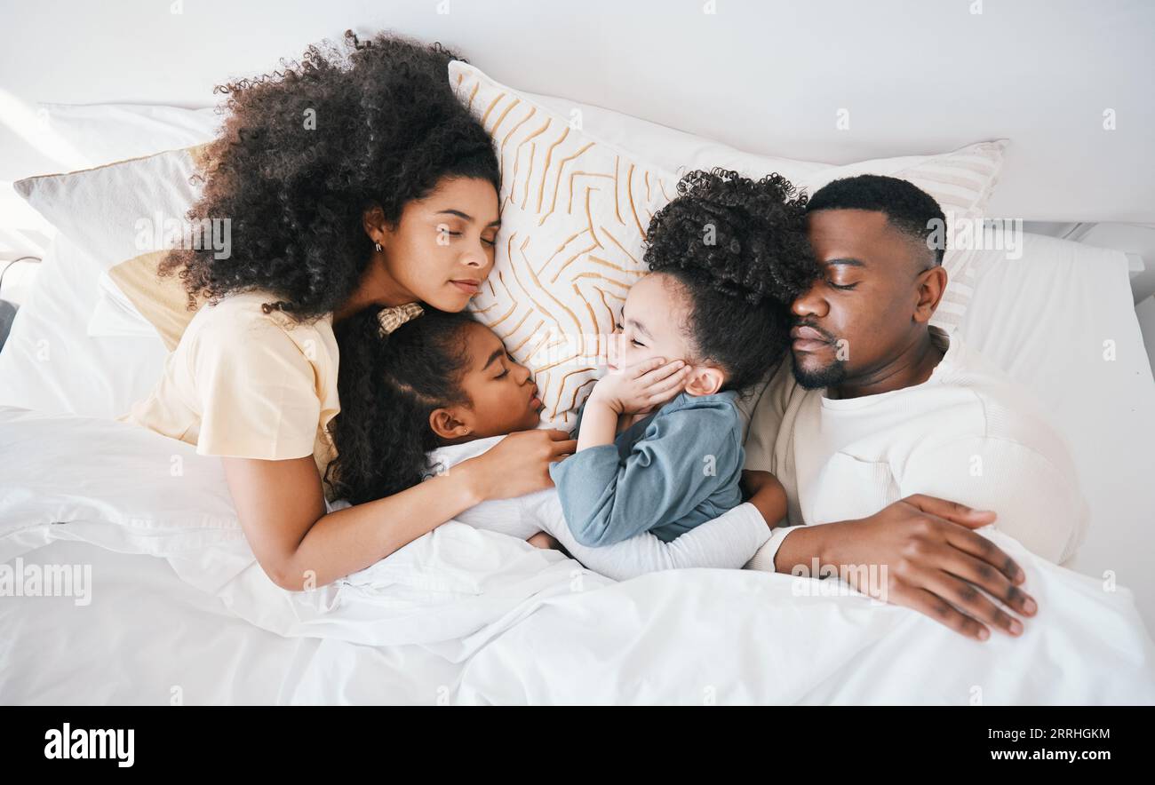Mama, Vater und Kinder im Bett, schlafen und Blick von oben für Pflege, Umarmung und Entspannung zusammen im Urlaub in der Familie zu Hause. Mutter, Vater und müde Kinder für Stockfoto
