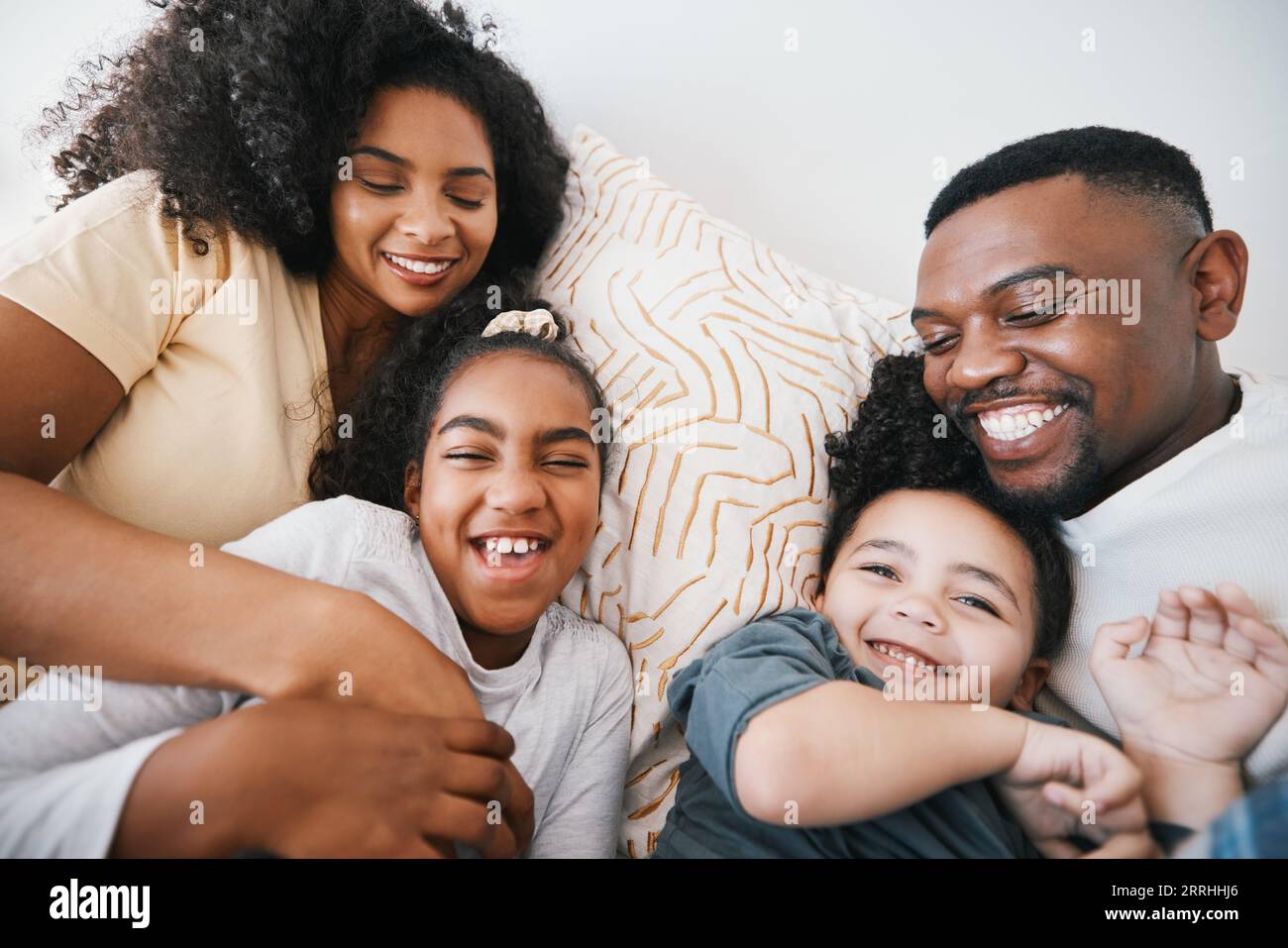 Mama, Vater und Kinder im Bett mit Kitzeln, Comic-Witz und Lachen mit Bindung, Pflege und Liebe in der Familie zu Hause. Schwarzer Mann, Mutter und Tochter mit Lächeln Stockfoto
