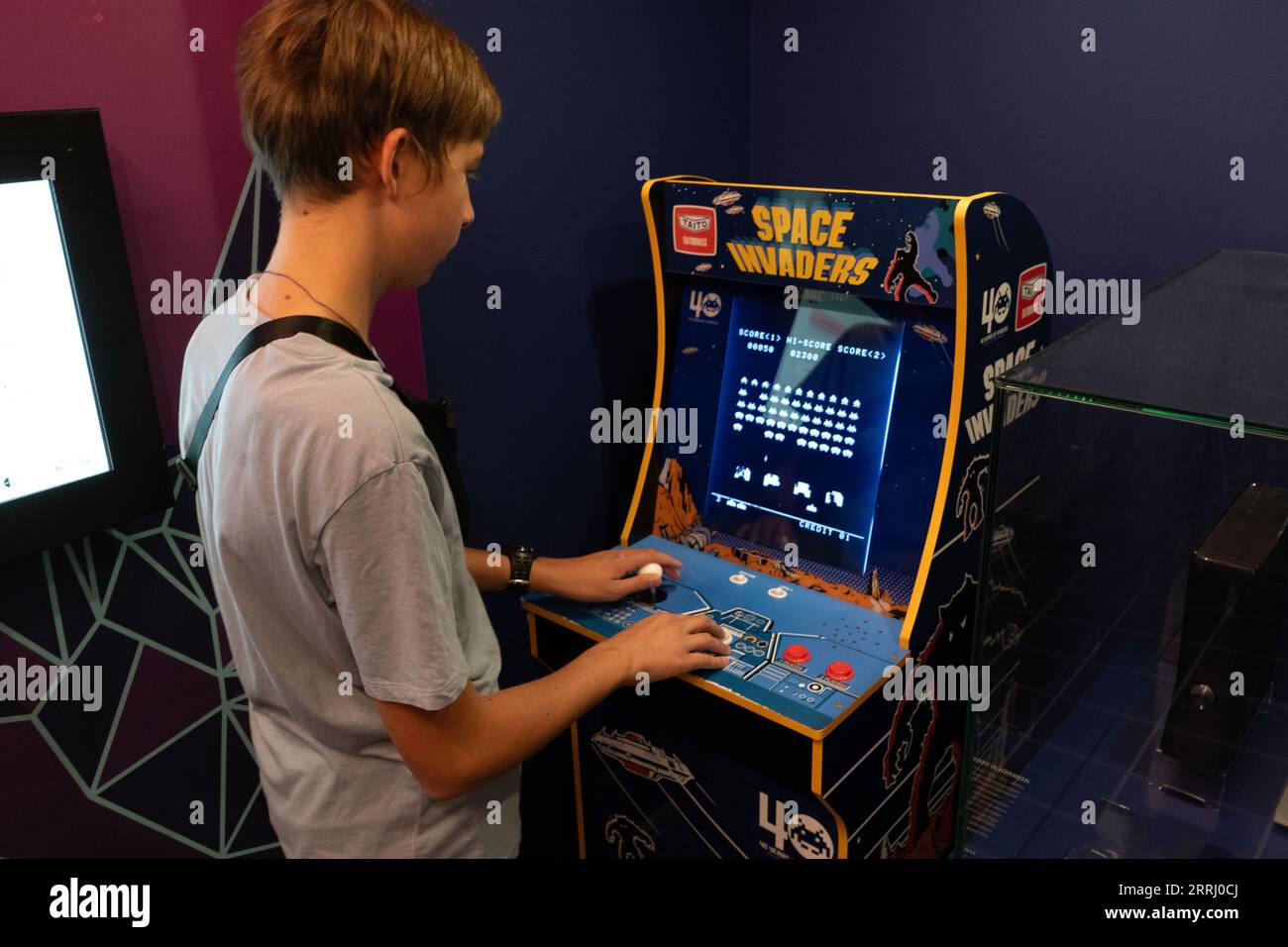 Raumeindringlinge Taito Spielmaschine. Simple Space Arcade in einem alten 8-Bit-Retro-Video. Boy spielt den klassischen Spielautomaten. Warschau, Polen - 28. Juli 2023. Stockfoto