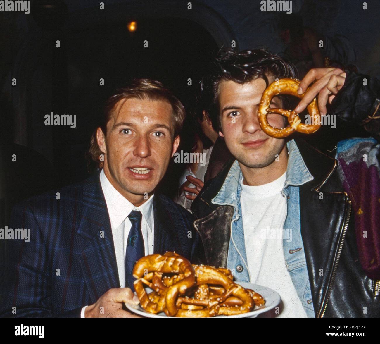 Michael Lesch, deutscher Schauspieler (links) und Kollege Marek Erhardt mit Laugenbrezeln auf dem Weihnachtsmarkt, Deutschland um 1991. Stockfoto