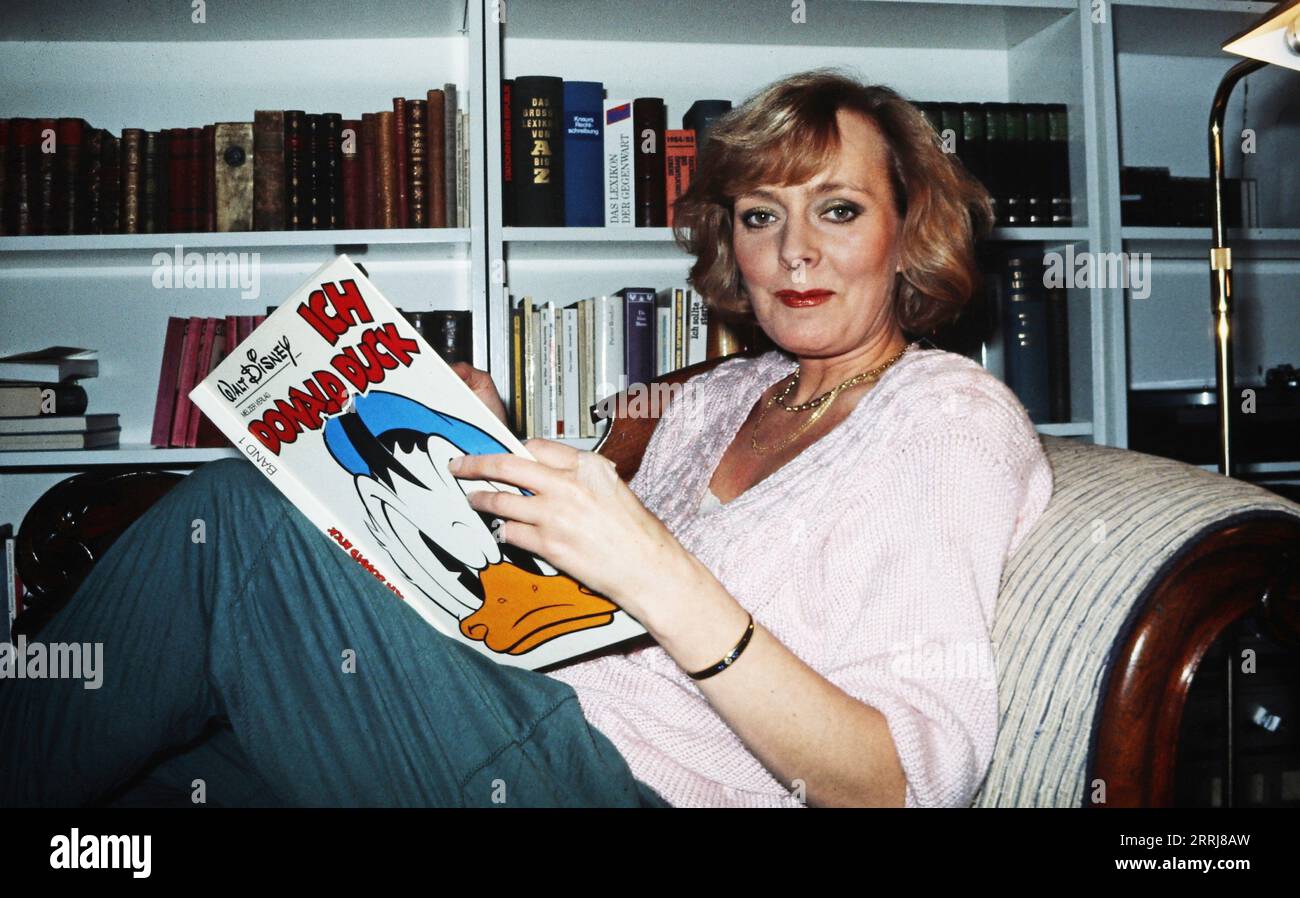 Victoria Voncampe, deutsche Programmsprecherin und Schauspielerin, zuhause in ihrer Wohnung beim Lesen von Donald Duck Comics, Deutschland um 1997. Stockfoto