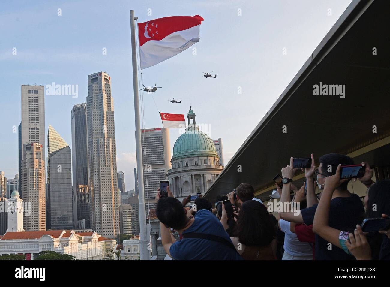 220809 -- SINGAPUR, 9. August 2022 -- die Leute machen Fotos, während ein Hubschraubergeschwader während der 57. Feierlichkeiten zum Nationalfeiertag in Singapur am 9. August 2022 vorbeifährt. SINGAPUR-NATIONALFEIERTAGE ThenxChihxWey PUBLICATIONxNOTxINxCHN Stockfoto