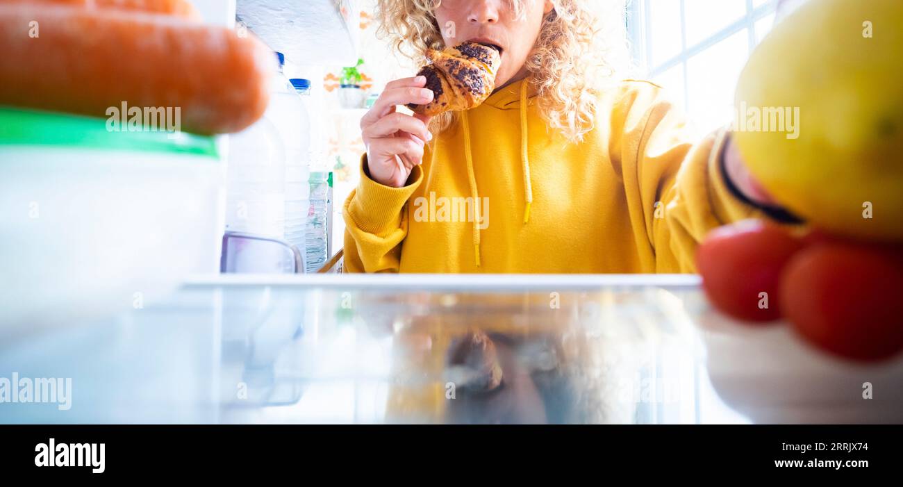 Banner von Leuten, die Lebensmittel aus dem Kühlschrank nehmen. Ungesunde Ernährungsstörungen Lebensweise. Schlechte Gewohnheiten und Diätkonzept. Frau isst Schokoladen-Croissant und sucht nach etwas anderem zu essen. Emotionales Essen Stockfoto