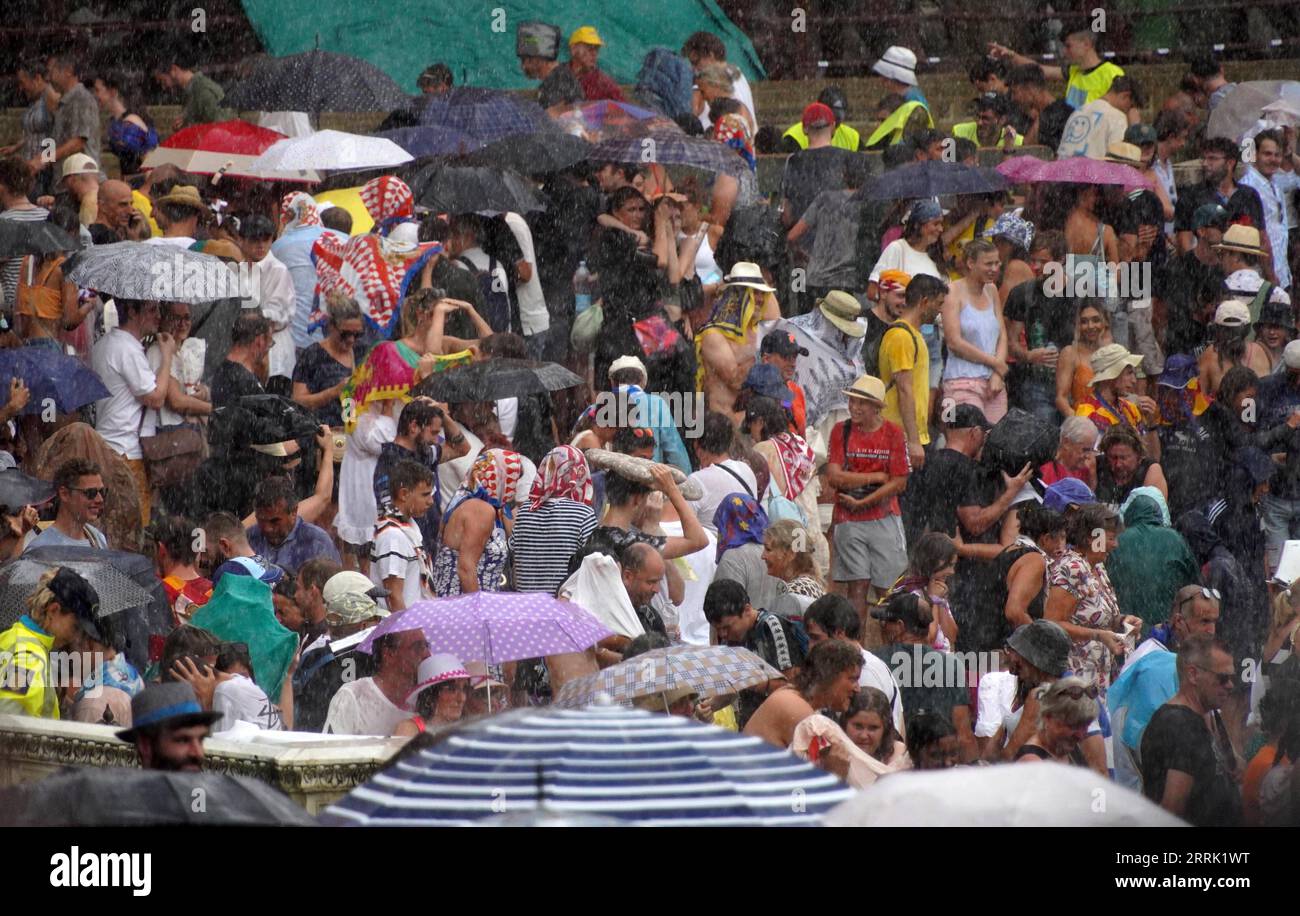 220817 -- SIENA, 17. Aug. 2022 -- Zuschauer bereiten sich vor, nach der Aussetzung des Pferderennens Palio in Siena, Italien, am 16. Aug. 2022 zu gehen. Das Pferderennen Palio wurde wegen des Regens auf den 17. August verschoben. Das historische Pferderennen Palio findet auch in diesem Jahr nach einer zweijährigen Pause wegen der COVID-19-Pandemie statt. ITALIEN-SIENA-PFERDERENNEN PALIO JinxMamengni PUBLICATIONxNOTxINxCHN Stockfoto