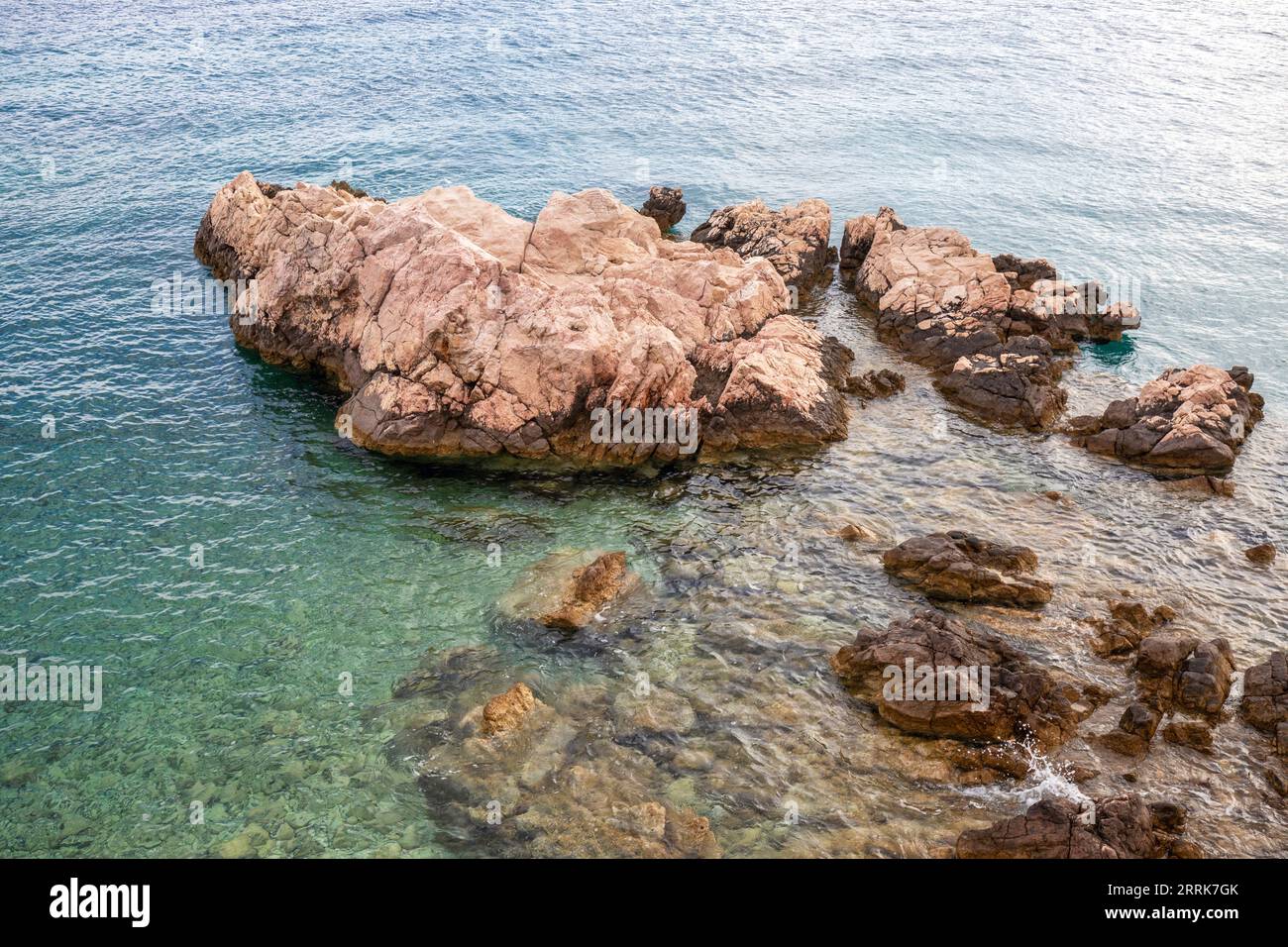 Kroatien, Primorje-Gorski Komitat Kotar, Insel Krk, Baska, die felsigen Klippen in der Nähe des Strandes Mali Raj und die Insel Prvic im Hintergrund Stockfoto