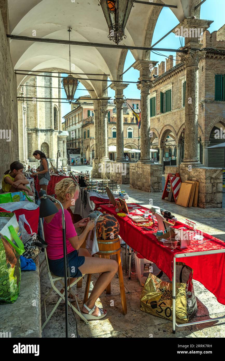 Stände mit handgefertigten Objekten unter der Loggia dei Mercanti. Die Frau produziert das Ascoli-Tombolo. Ascoli Piceno, Marche Region, Italien, Europa Stockfoto