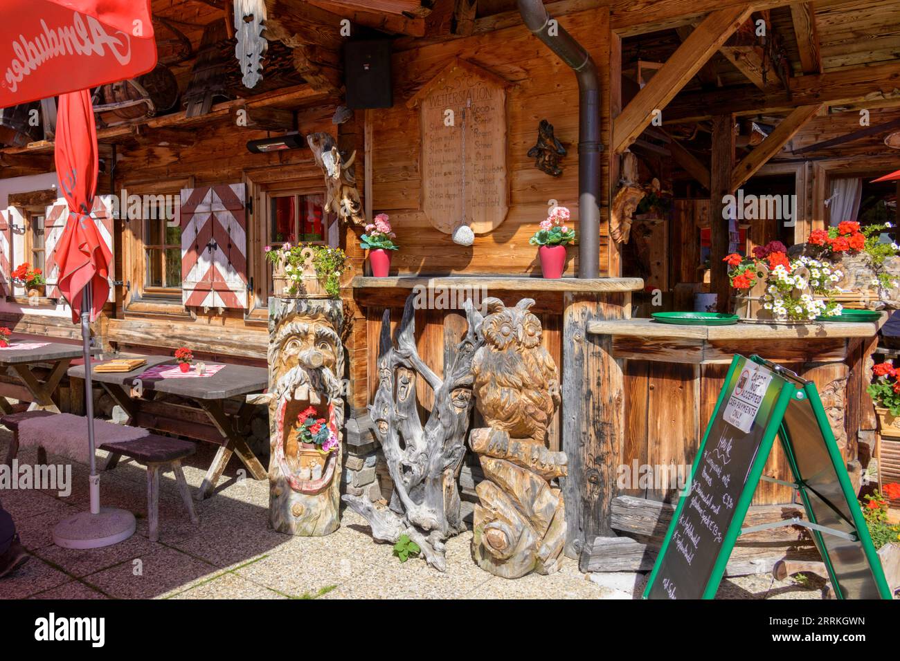 Österreich, Tirol, Zillertal, Außentresen der Eggalm mit Holzskulpturen. Stockfoto