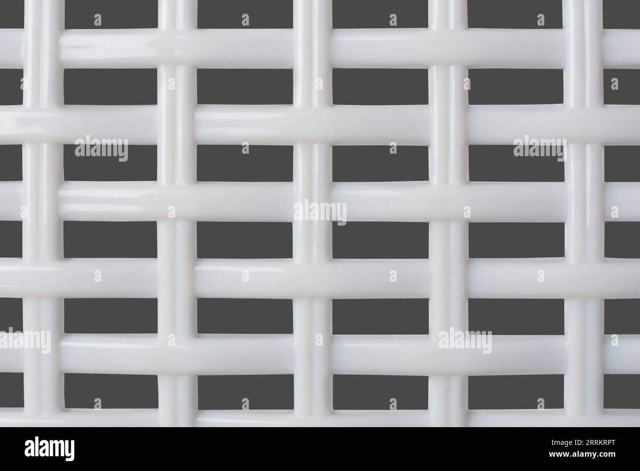 Nahaufnahme der abstrakten, weißen geometrischen Hintergrundtextur des Kunststoffgitters für das Entwerfen, Netzmusterstruktur im gesamten Rahmen isoliert auf Grau Stockfoto