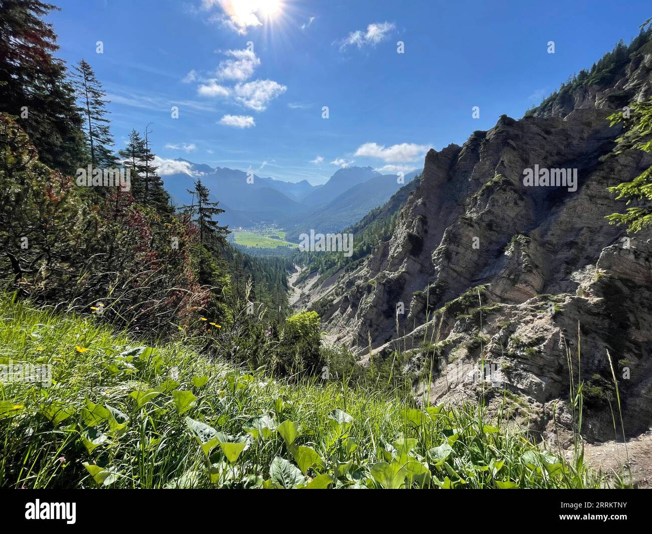 Blick von der Sattelklamm nach Scharnitz und die dahinter liegenden Karwendelberge, Pleisenspitze, hoher Gleirsch, Sommer, Karwendelgebirge, Sonne, Berge, Wolken, Natur, Aktivität, Tirol Plateau, Scharnitz, Tirol, Österreich Stockfoto