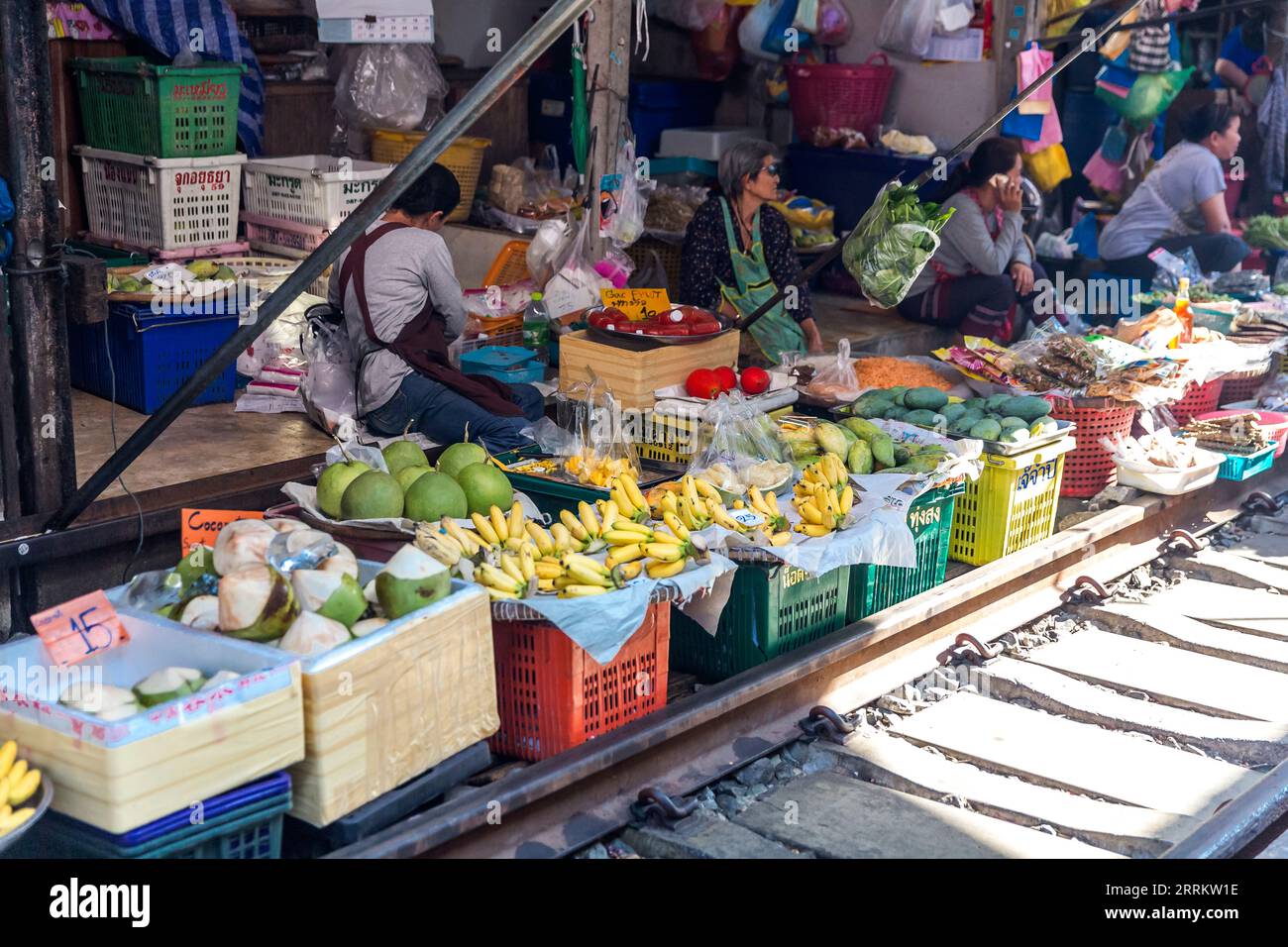 Verkauf von Lebensmitteln auf Schienen, Maeklong Railway Market, Talad Rom Hub Railway Market, in der Nähe von Bangkok, Samut Songkhram, Thailand, Asien. Stockfoto