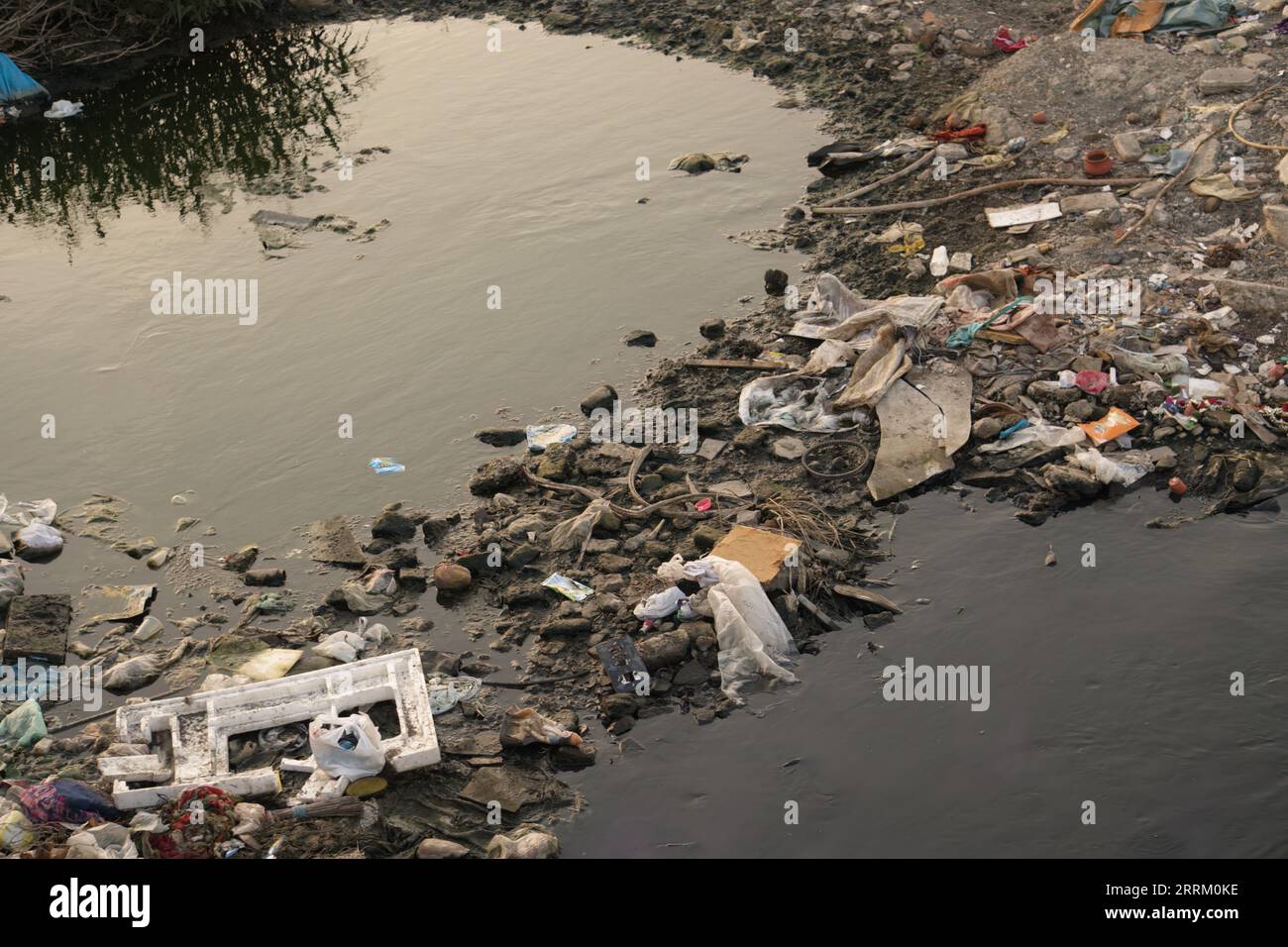 Rajkot, Indien. September 2023. Das kontaminierte Wasser des Flusses Aji in der Nähe des Ramnath-Tempels in Rajkot hat sich aufgrund von Plastiktüten, Flaschen und verschiedenen anderen Abfallstoffen schwarz gefärbt. Quelle: Nasirchan/Alamy Live News Stockfoto