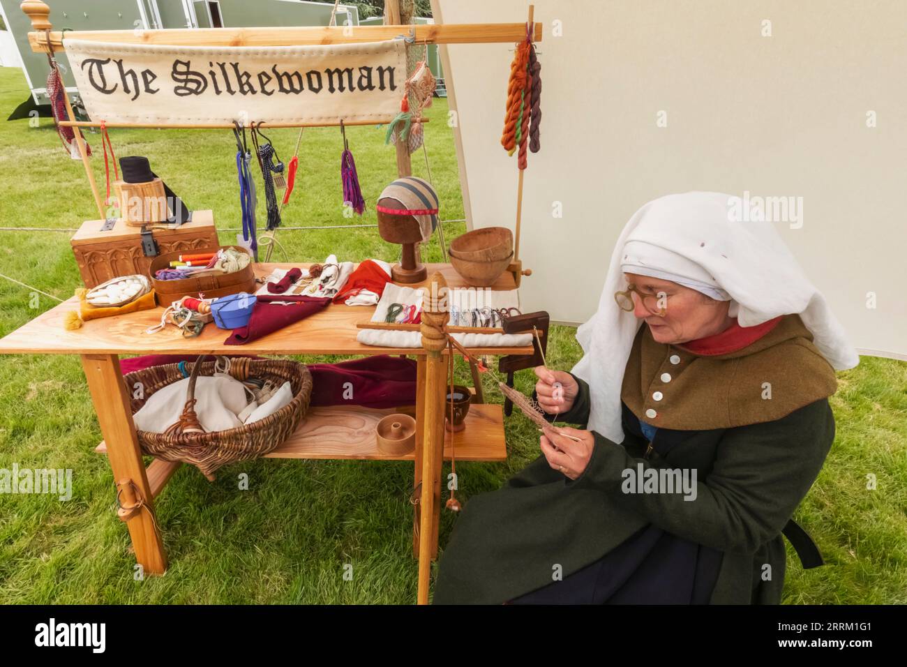 England, Kent, Maidstone, Leeds, Leeds Castle, Mittelalterliches Festival, Portrait of Woman in Medieval Costume Weaving Seide Stockfoto