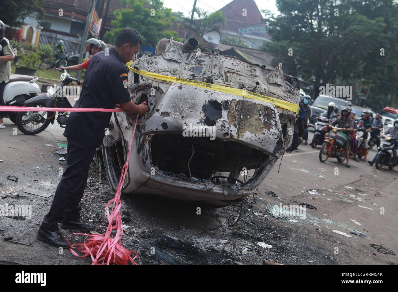 News Bilder des Tages 221002 -- MALANG, 2. Oktober 2022 -- Ein Polizist fesselt ein Seil an das Wrack eines verbrannten Autos vor dem Kanjuruhan-Stadion in Malang in der Provinz Ost-Java, Indonesien, 2. Oktober 2022. Mindestens 129 Menschen wurden getötet und 180 weitere verletzt, nachdem am Samstagabend bei einem Fußballspiel im indonesischen Malang in der Provinz Ost-Java Stampede und Zusammenstöße stattgefunden hatten, teilte die indonesische Polizei am Sonntag mit. Der Provinzpolizeichef Nico Afinta sagte auf einer Pressekonferenz, dass das Chaos am späten Samstag im Kanjuruhan-Stadion in Malang stattfand, nachdem der AREMA Malang-Club gegen Perseba verloren hatte Stockfoto