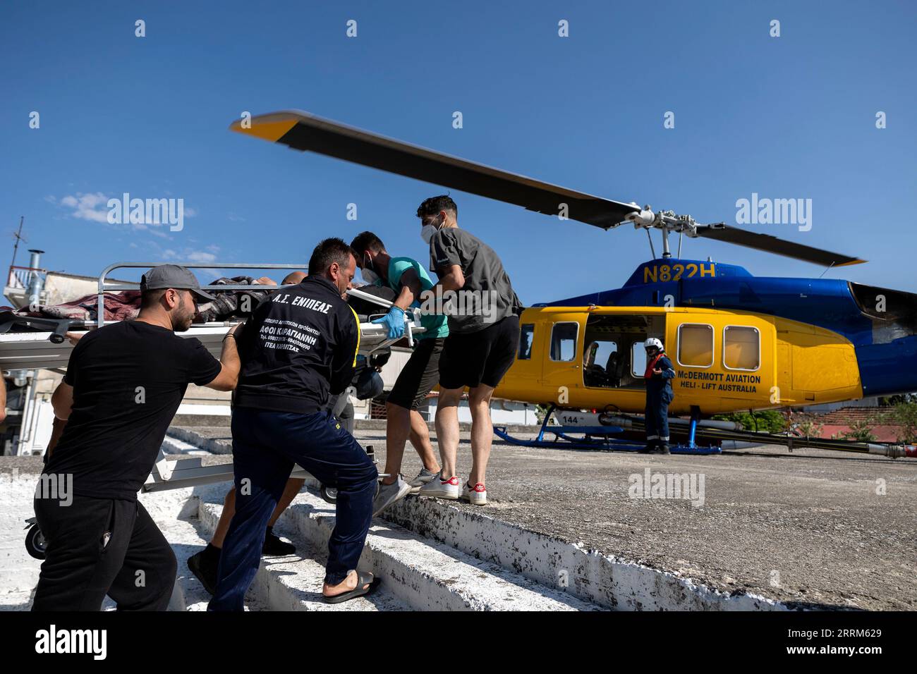 Karditsa, Griechenland. September 2023. Die Menschen tragen einen Evakuierten zu einem Rettungshubschrauber im Dorf Palamas in der Nähe der Stadt Karditsa. Nachdem der Sturm „Daniel“ riesige Niederschlagsmengen verursacht hat, kommt der Schaden nun ans Licht. Hunderte von Menschen mussten gerettet werden, da sie aufgrund der Wassermassen tagelang von der Umgebung abgeschnitten waren. Quelle: Yorgos Karahalis/dpa/Alamy Live News Stockfoto