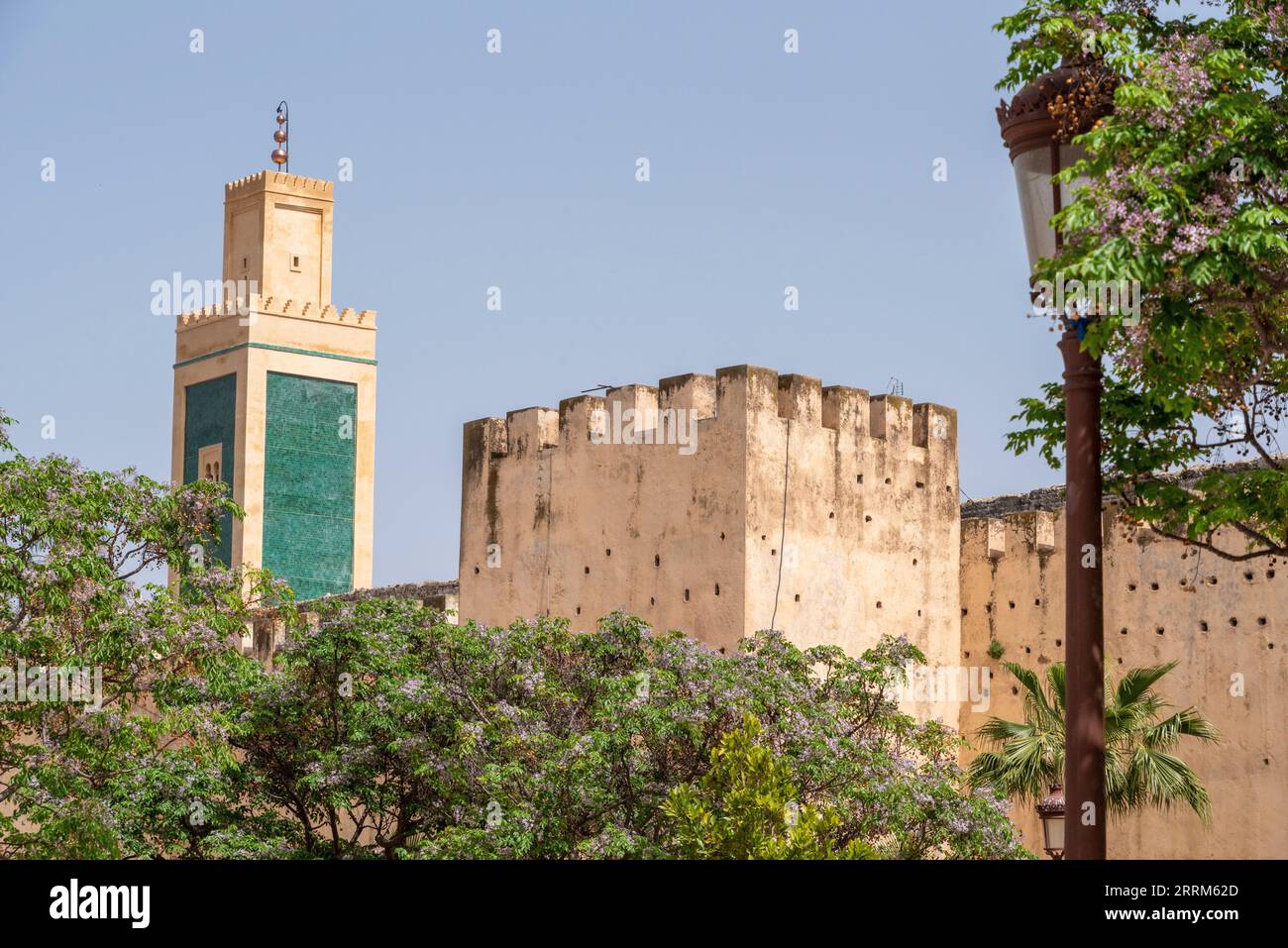 Starke alte Stadtmauer rund um die Innenstadt von Meknes, Lalla Aouda Moschee im Hintergrund, Marokko Stockfoto