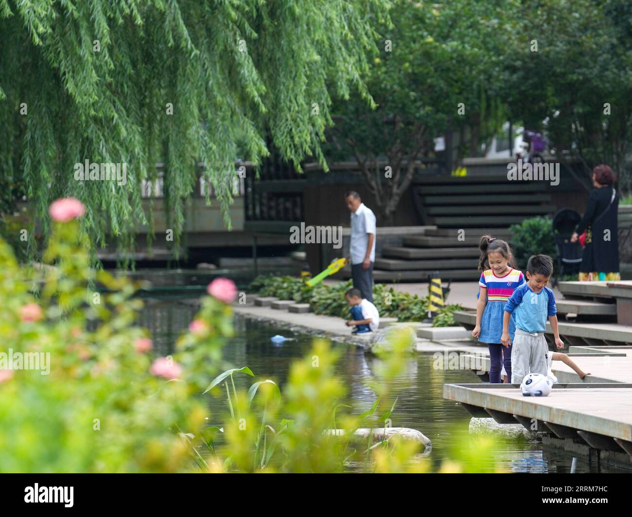 221005 -- PEKING, 5. Oktober 2022 -- Menschen spielen am 29. August 2022 im Dongcheng-Abschnitt des Yuhe-Flusses in Peking, der Hauptstadt Chinas. Die chinesischen Behörden haben geplant, die Beijing Central Axis als Chinas Projekt zur Anwendung des Weltkulturerbes 2024 zu empfehlen, so die National Cultural Heritage Administration. Die Pekinger Zentralachse ist 7,8 Kilometer lang, beginnend vom Yongding-Tor im Süden der Stadt bis zum Trommelturm und Glockenturm im Norden. Die meisten der großen Gebäude der Altstadt Pekings befinden sich entlang dieser Achse. Die Mittelachse ist das Rückgrat von Stockfoto