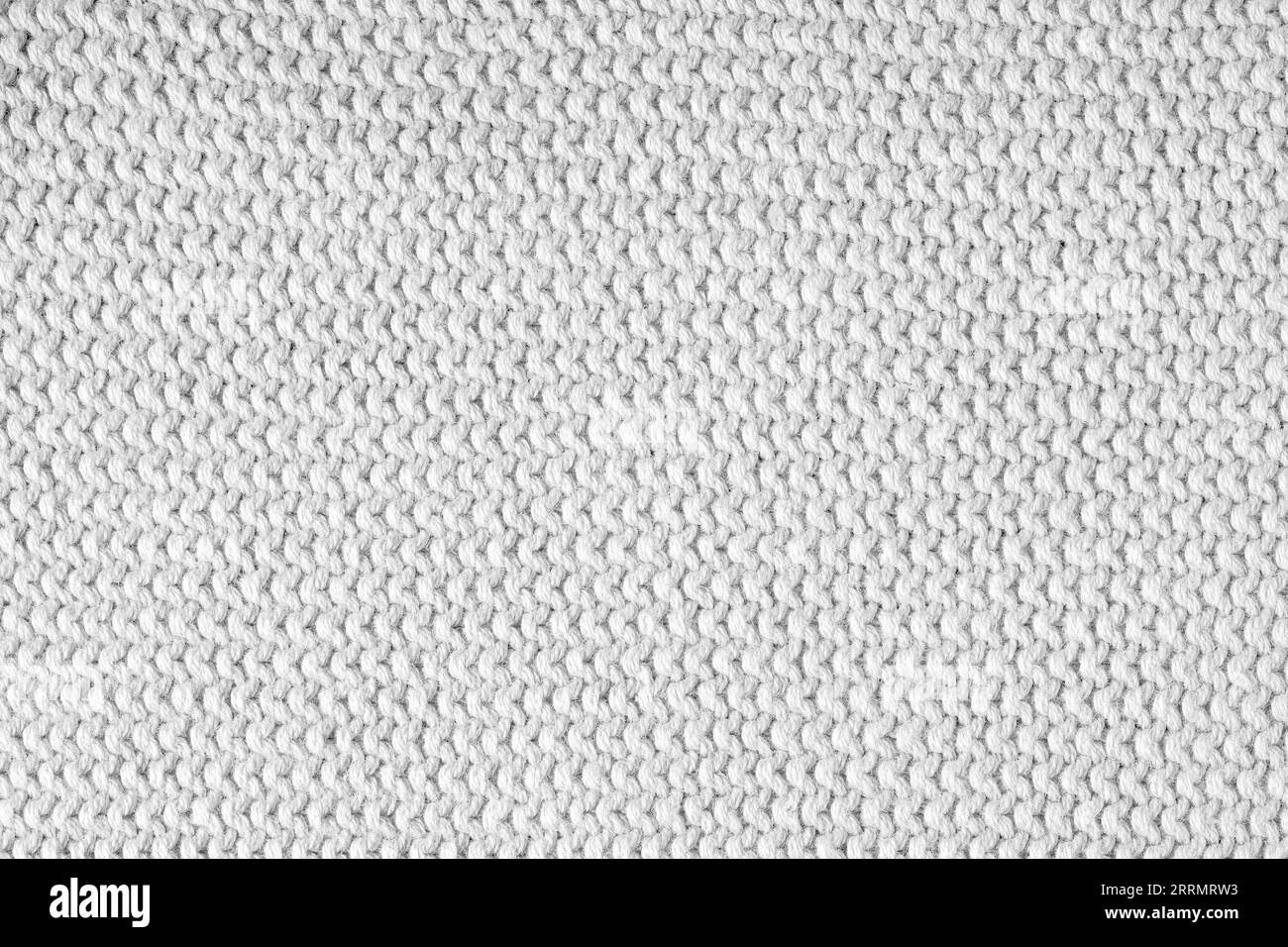 Gestrickter Hintergrund. Textur von grobem horizontalen Stricken aus weißen Wollfäden. Stockfoto