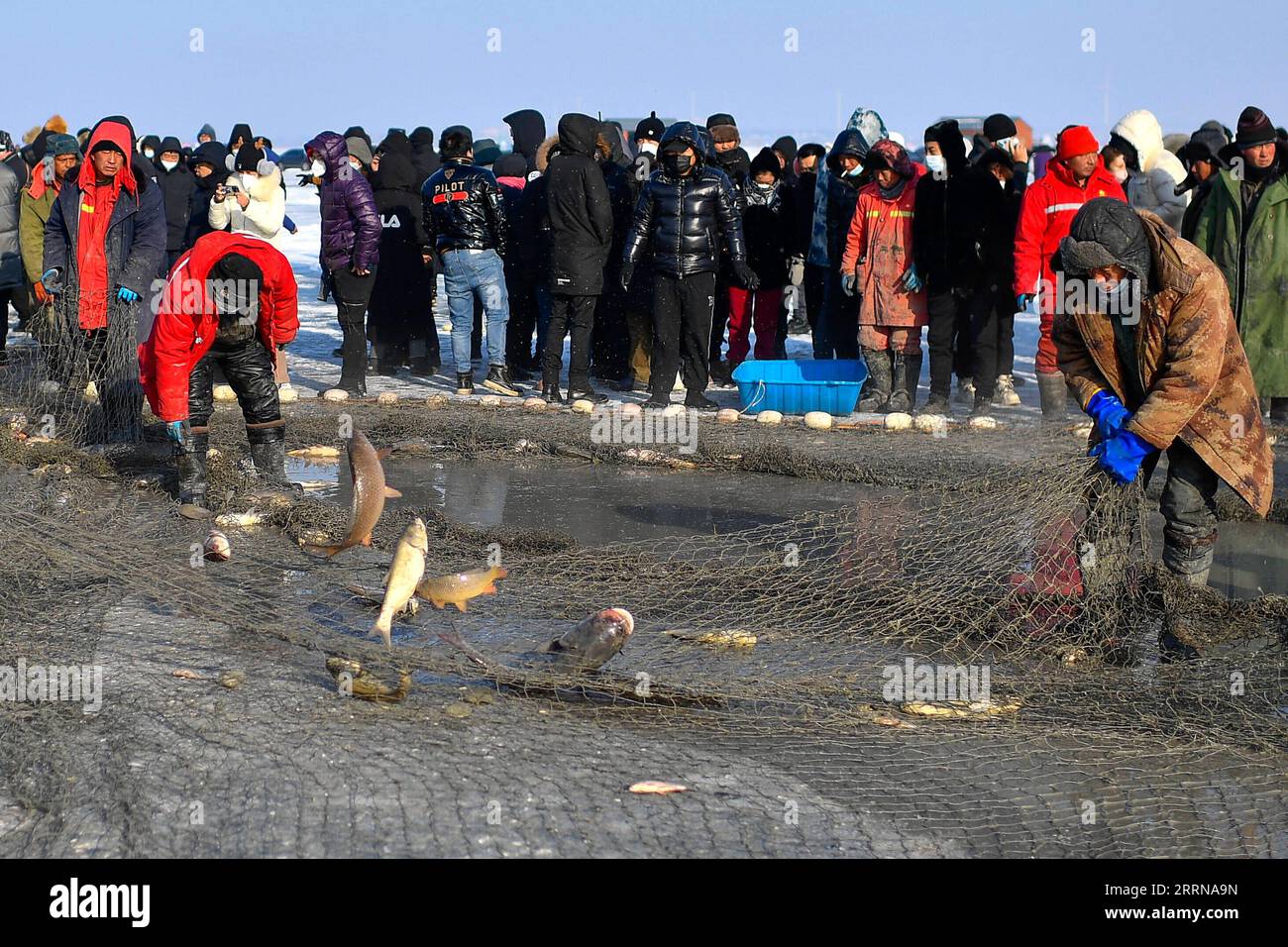 221228 -- SONGYUAN, 28. Dezember 2022 -- einheimische Fischer fangen Fisch auf dem gefrorenen Chagan-See in der Stadt Songyuan, nordöstliche chinesische Provinz Jilin, 28. Dezember 2022. Am Mittwoch wurde am Chagan Lake ein Festival zum Thema Winterfischen eröffnet, das den Beginn der jährlichen goldenen Jahreszeit für Winterfischerei markiert. Der Chagan Lake in Songyuan City ist einer der größten Süßwasserseen Chinas mit zahlreichen Fischereiressourcen. Jahrhundertelang haben die am Chagan Lake lebenden Einheimischen die Tradition des Eisfischens lebendig gehalten, indem sie Löcher durch das dicke Eis bohren und Netze in das eisige Wasser werfen, um zu fangen Stockfoto