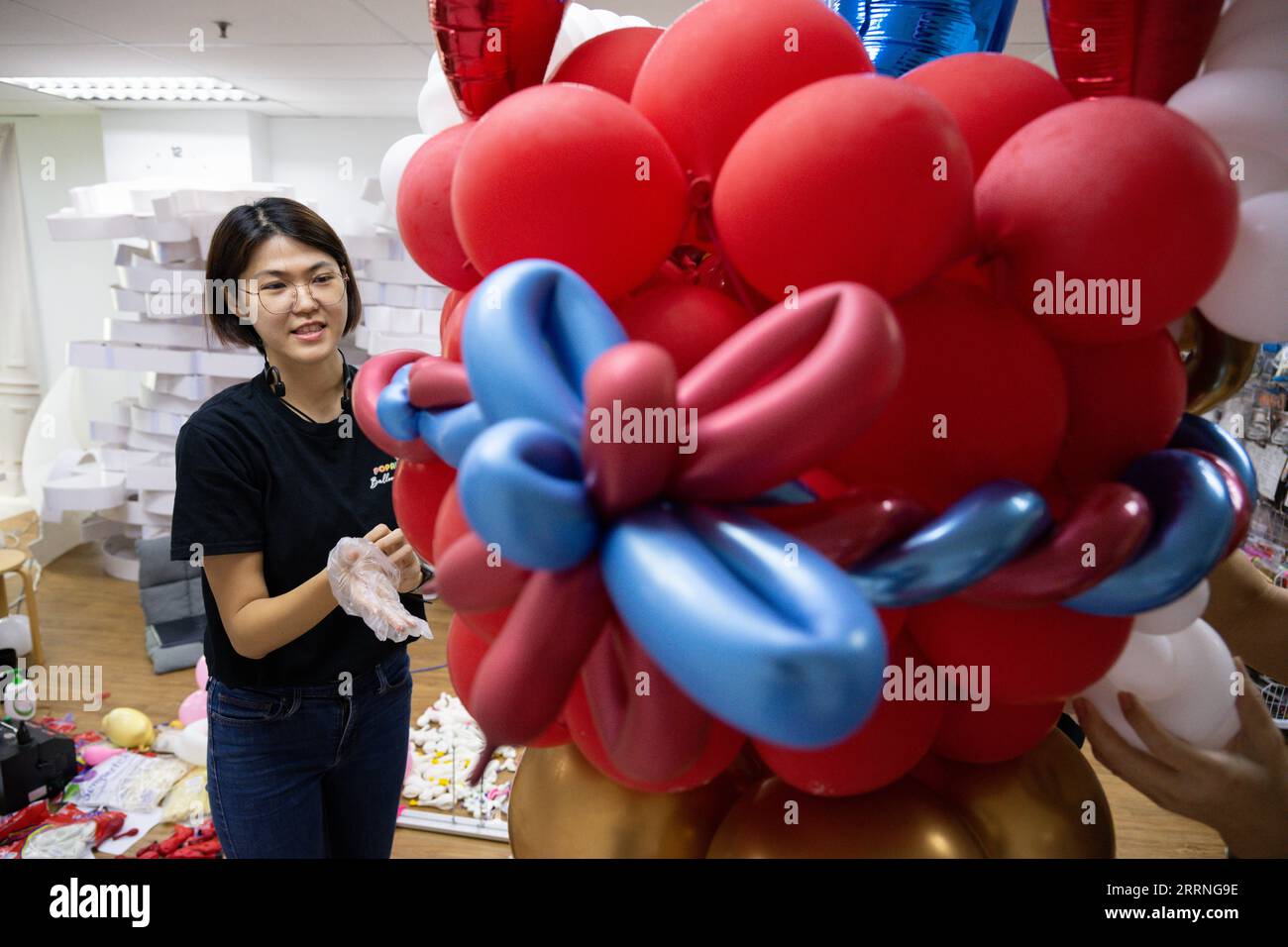 230111 -- KUALA LUMPUR, 11. Januar 2023 -- Syndy Tan Sing YIT poliert in ihrer Werkstatt in der Nähe von Kuala Lumpur, Malaysia, 11. Januar 2023 eine Löwen-Ballon-Skulptur. Syndy Tan Sing YIT ist eine malaysische Ballonstilistin, die seit mehr als einem Jahrzehnt an der Ballonmodellierung arbeitet. Sie schuf Lion Dance Ballon Skulpturen, indem sie sich auf Lion Dance Grafiken und Bilder bezog. Laut Tan benötigt die Herstellung einer Ballonskulptur mehr als 500 Ballons, bei denen es wichtig ist, die Farbe der Augen und den Anteil der Lippen und des Kinns anzupassen, um den Charme des Löwen hervorzuheben. MALAIISCH Stockfoto