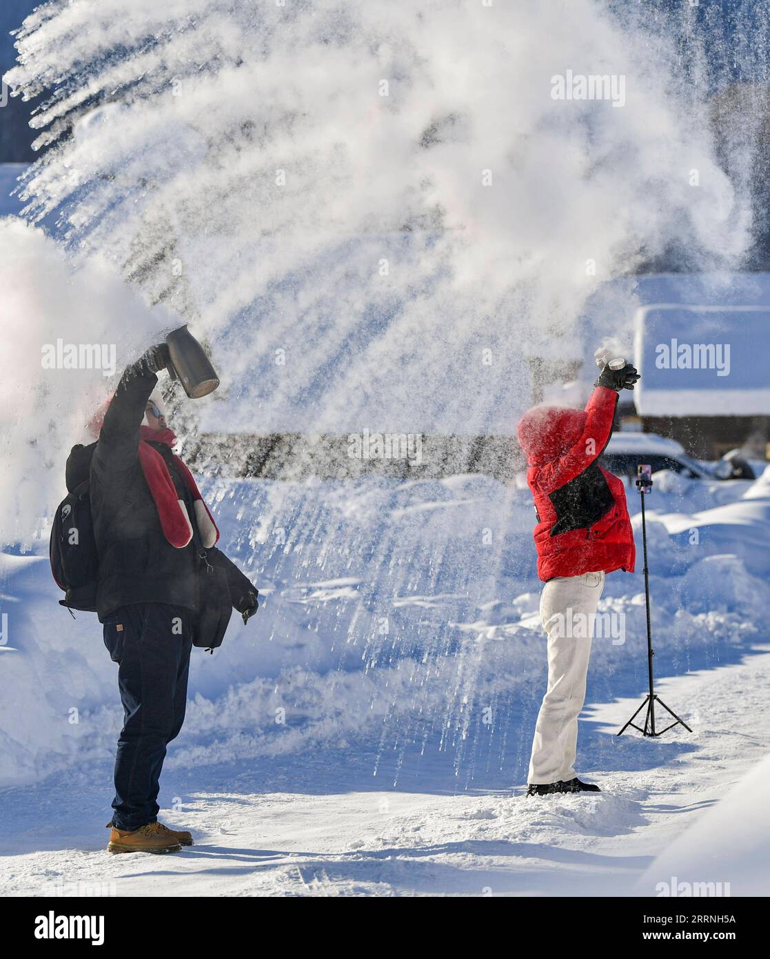 230113 -- ALTAY, 13. Januar 2023 -- Touristen Livestream ein Spiel, in dem sie Wasser in Eis spritzen bei extrem kaltem Wetter in der Präfektur Altay, Nordwestchina Xinjiang Uygur Autonomous Region, 12. Januar 2023. Die Präfektur Altay ist bekannt für ihre lange Wintersaison, die bis zu acht Monate im Jahr dauern kann. Es zieht Skifahrer weltweit mit seiner riesigen Fläche an natürlichem Pulverschnee an. Die Region hat sich in den letzten Jahren zum Ziel gesetzt, den Wintertourismus anzukurbeln und Besucher mit Skifahren, Eisfischen und anderen Winteraktivitäten zu begeistern. Zwischen dem 2022. Dezember und dem 11. Januar 2023 wurden dort rund 1,02 Millionen Touristen aufgenommen. C Stockfoto