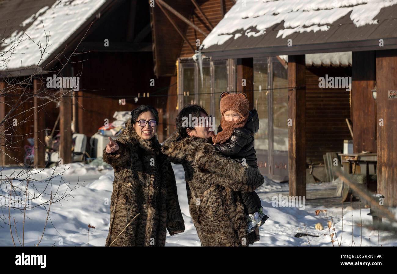 230113 -- GENHE, 13. Januar 2023 -- dieses Foto, das am 13. Januar 2023 aufgenommen wurde, zeigt Juele mit seiner Familie in einer neuen Umsiedlungsgemeinde in der Gemeinde Aoluguya Ewenki, der Stadt Genhe in der Autonomen Region Innere Mongolei in Nordchina. Alle zwei oder drei Tage fährt Juele Bulituotian in die Jinhe-Waldkette, etwa 80 Kilometer von der Stadt Genhe entfernt. Dort findet der 39-jährige Aoluguya Ewenki-Hirte, der einen traditionellen Pelzmantel trägt, sein Rentier, das auf der Jagd ist. Anstatt Rentiere in einer Scheune zu halten, lassen die Ewenki-Hirten die Tiere im Wald leben und kontrollieren sie alle paar Tage. Juele besitzt mehr als 60 Stockfoto