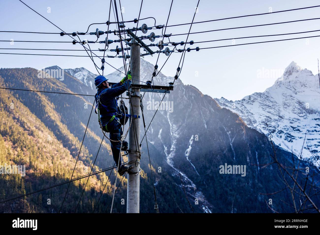 230114 -- DEQEN, 14. Januar 2023 -- Wangden inspiziert Stromleitungen im Dorf Yubeng im Deqen County, Provinz Yunnan im Südwesten Chinas, 9. Januar 2023. Wangden, 34, ist Associate Director der Yunnan-Niederlassung des Yanmen-Stromversorgungswerks von China Southern Power Grid im Deqen County. 2015 übernahm er die Instandhaltungsaufgaben in Yubeng, einem Dorf am Fuße der schneebedeckten Berge. Als Yubengs am längsten beschäftigter Stromversorger hat der Mann enorme Veränderungen im Dorf erlebt. In der Vergangenheit war Yubeng praktisch von der Außenwelt abgeschnitten, Stockfoto