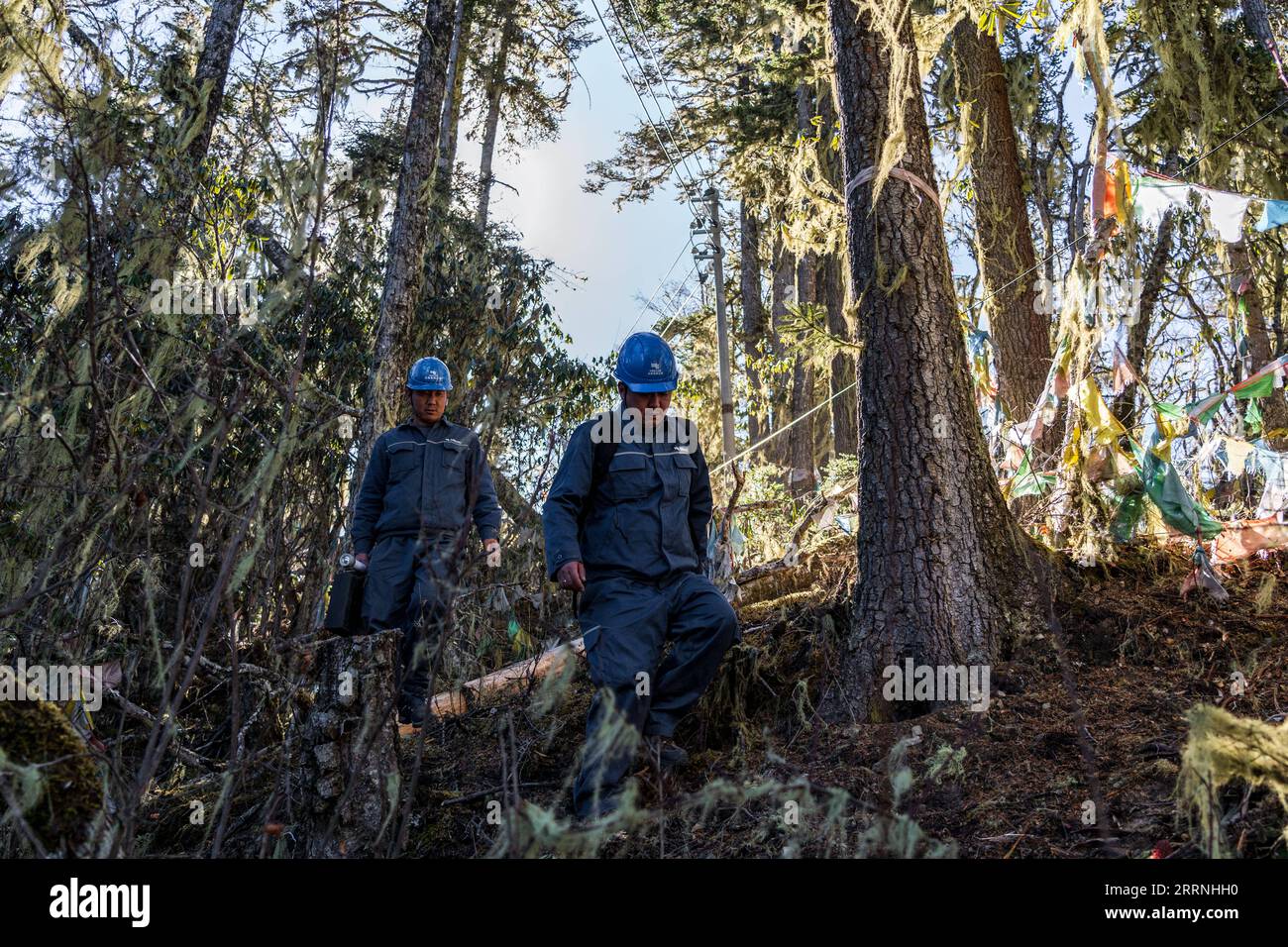 230114 -- DEQEN, 14. Januar 2023 -- Wangden L und sein Kollege Zhang Jincheng inspizieren Stromleitungen auf einem Berg im Deqen County, südwestchinesische Provinz Yunnan, 9. Januar 2023. Wangden, 34, ist Associate Director der Yunnan-Niederlassung des Yanmen-Stromversorgungswerks von China Southern Power Grid im Deqen County. 2015 übernahm er die Instandhaltungsaufgaben in Yubeng, einem Dorf am Fuße der schneebedeckten Berge. Als Yubengs am längsten beschäftigter Stromversorger hat der Mann enorme Veränderungen im Dorf erlebt. In der Vergangenheit war Yubeng praktisch Cu Stockfoto