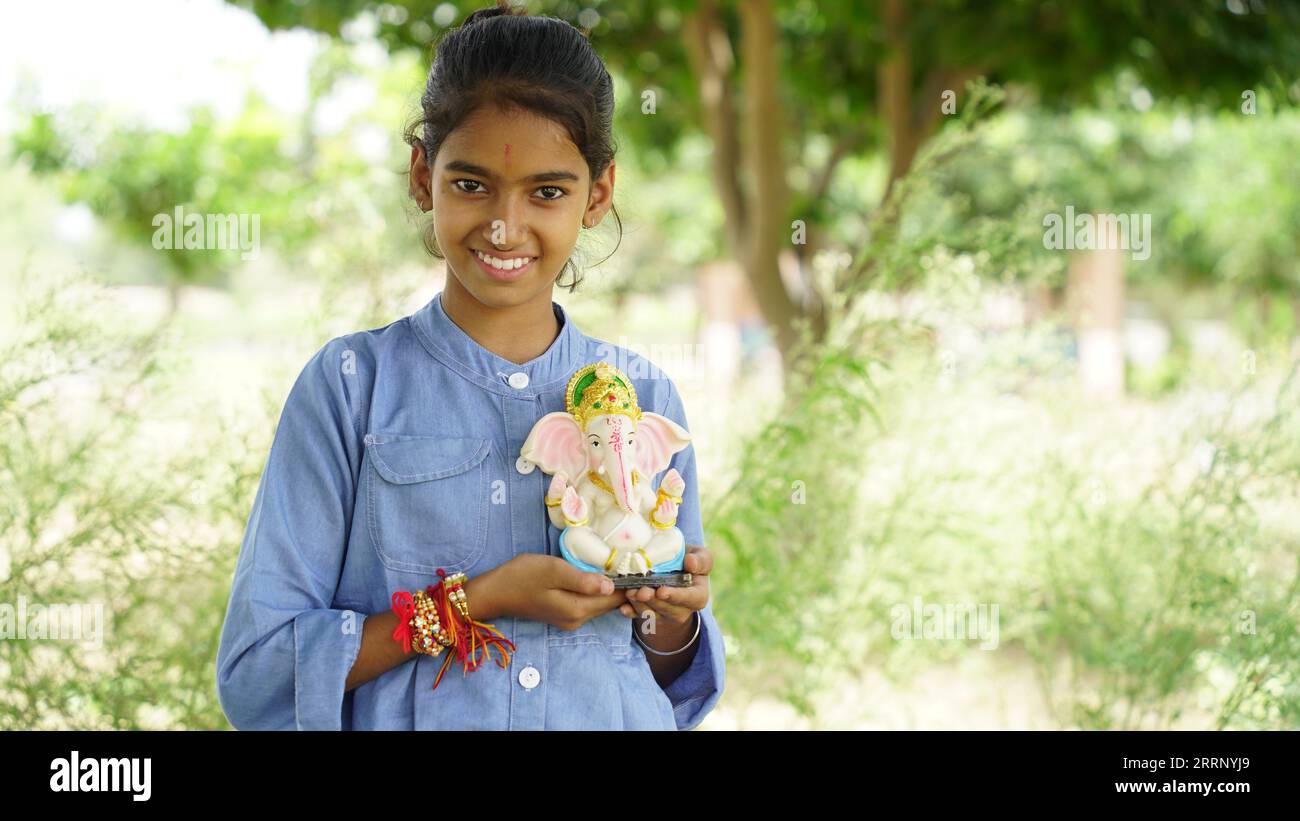 Kleines indisches Mädchen Kind mit Lord ganesha und Beten, indisches ganesh-Festival oder Diwali-Festival Stockfoto