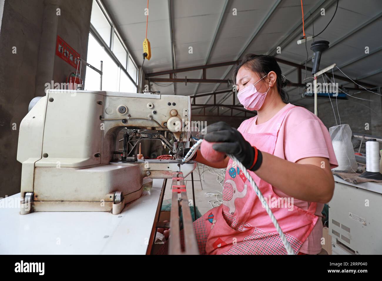 LUANNAN COUNTY, Provinz Hebei, China - 20. August 2020: Arbeiter verwenden Nähmaschinen, um Netzschwimmer in Fabriken zu nähen Stockfoto