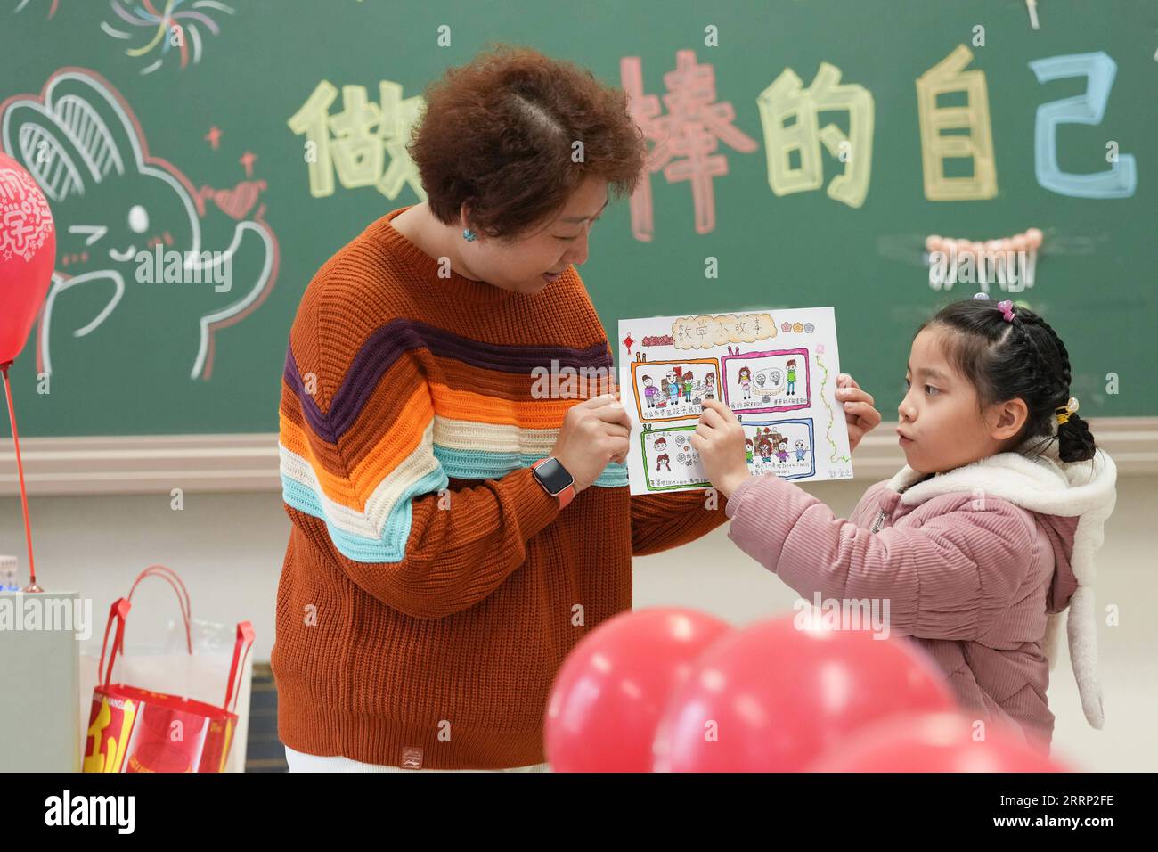 230213 -- PEKING, 13. Februar 2023 -- Schüler Guo Yizhi R zeigt ihre Hausaufgaben in einer Grundschule im Bezirk Chaoyang in Peking, Hauptstadt von China, 13. Februar 2023. Schüler der Grund- und Mittelschule in Peking kehrten am Montag zum Frühjahrssemester zur Schule zurück. CHINA-PEKING-SCHULE-NEUES SEMESTER CN JUXHUANZONG PUBLICATIONXNOTXINXCHN Stockfoto
