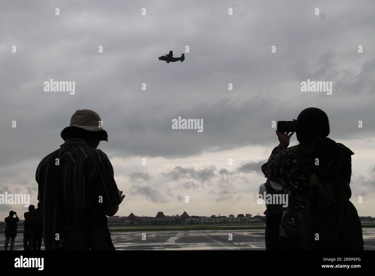230224 -- BOYOLALI, 24. Februar 2023 -- Menschen beobachten, wie ein Flugzeug während einer Operation der Wolkenaussaat auf der Luftwaffenbasis Adi Soemarmo in BOYOLALI, Zentral-Java, Indonesien, am 24. Februar 2023 fliegt. Foto von /Xinhua INDONESIA-BOYOLALI-CLOUD SEEDING BramxSelo PUBLICATIONxNOTxINxCHN Stockfoto