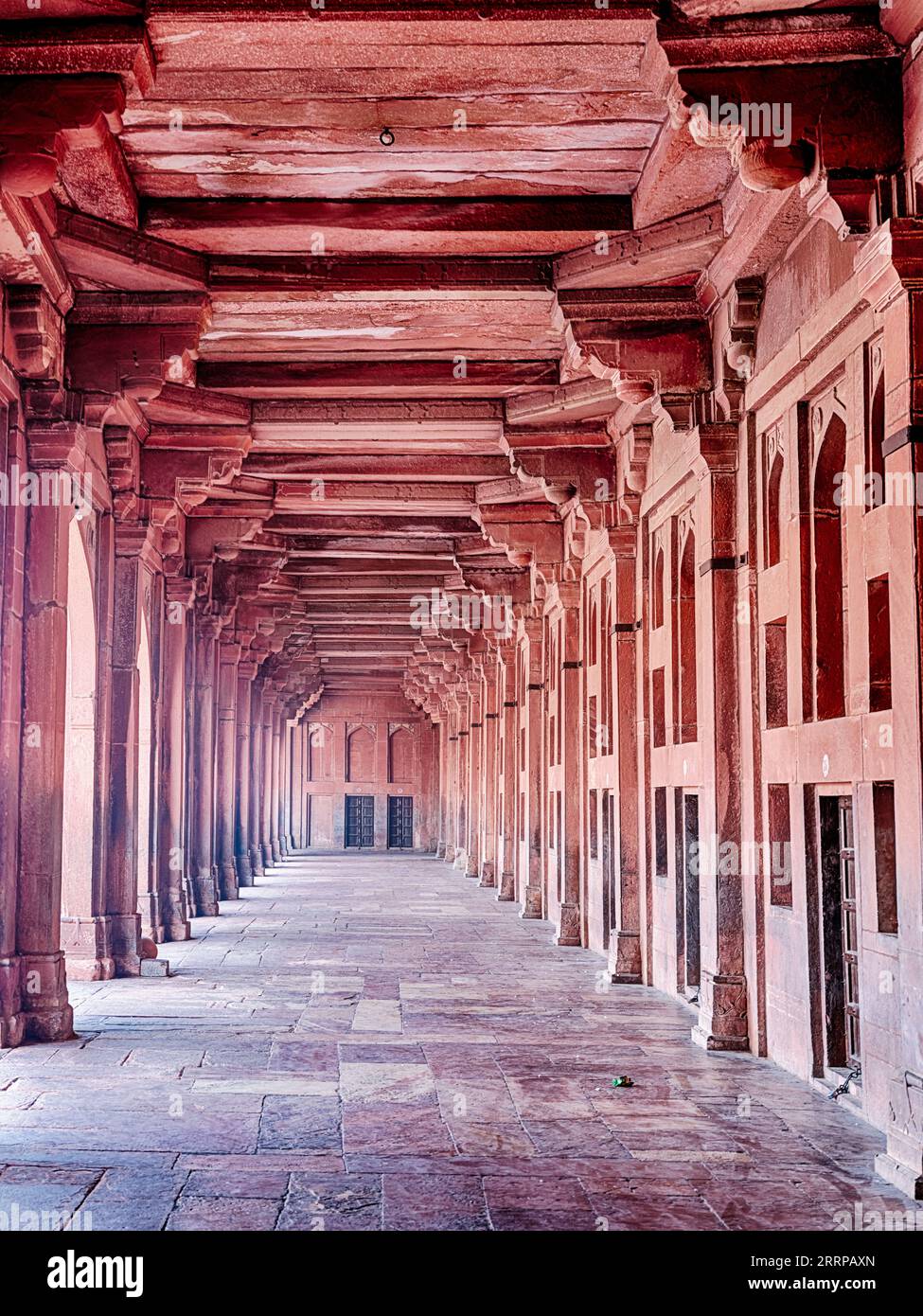 Ein langer Korridor aus rotem Sandstein befindet sich in der Moschee von Fatehpur Sikri in Rajasthan, Indien. Stockfoto