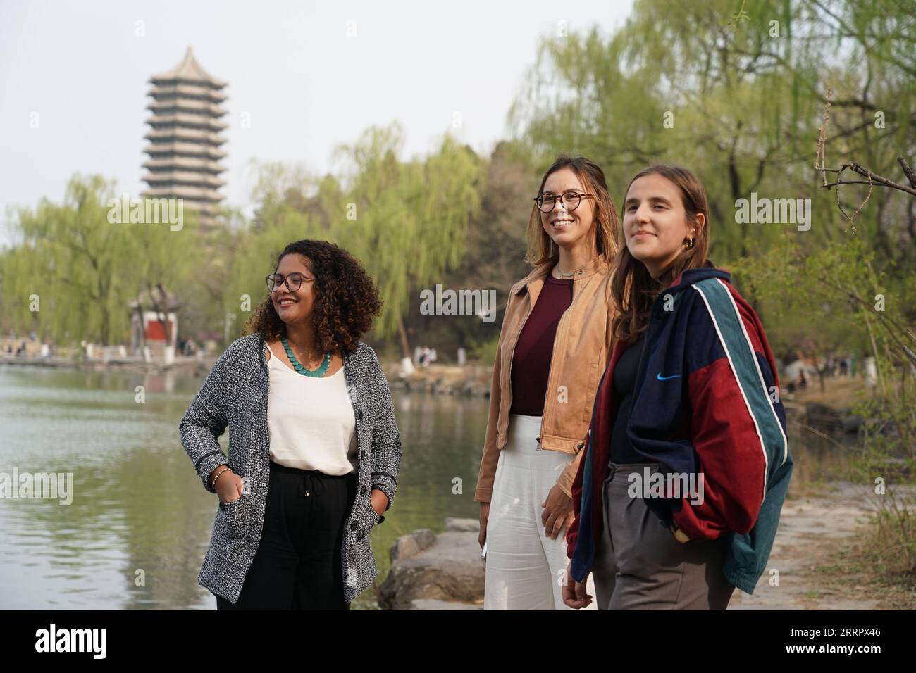 230415 -- PEKING, 15. April 2023 -- Rafaela L, Manuela C und Maria posieren für ein Foto in der Nähe des Weiming-Sees der Peking-Universität in Peking, Hauptstadt von China, 31. März 2023. Maria Eduarda Variani, Rafaela Viana dos Santos, Manuela Boiteux Pestana und Marco Andre Rocha Germano sind brasilianische Studenten, die im Master of China Studies an der Yenching Academy der Peking University in China studieren. Die vier interessieren sich seit ihrer Jugend für die chinesische Kultur. Nach der Ankunft in Peking sind sie beeindruckt von dem tiefgreifenden kulturellen Erbe der chinesischen Hauptstadt Stockfoto