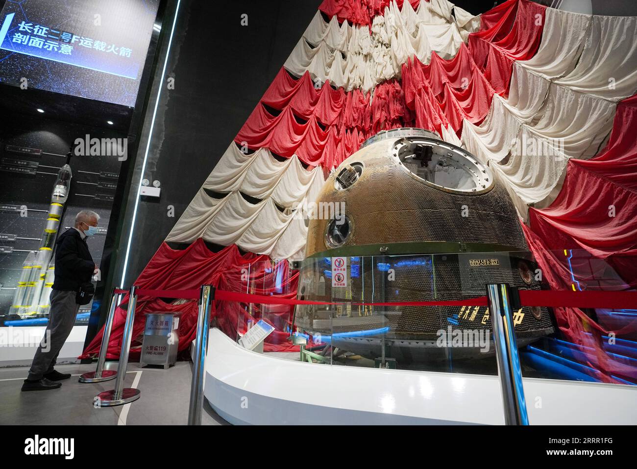 230424 -- PEKING, 24. April 2023 -- Ein Besucher sieht den Hauptfallschirm und die Rückkehrkapsel des Raumschiffs Shenzhou-4 im China Space Museum in Peking, Hauptstadt von China, 24. April 2023. Nach seiner Renovierung wurde das China Space Museum anlässlich des Weltraumtages von China am Montag wieder für die Öffentlichkeit geöffnet. Das Museum bietet Ausstellungsbereiche zu Themen wie Trägerraketen, Satelliten und bemannte Raumschiffe, die Besucher der Entwicklung der chinesischen Luft- und Raumfahrtindustrie näher bringen. CHINA-BEIJING-SPACE DAY-CHINA SPACE MUSEUM CN JUXHUANZONG PUBLICATIONXNOTXINXCHN Stockfoto