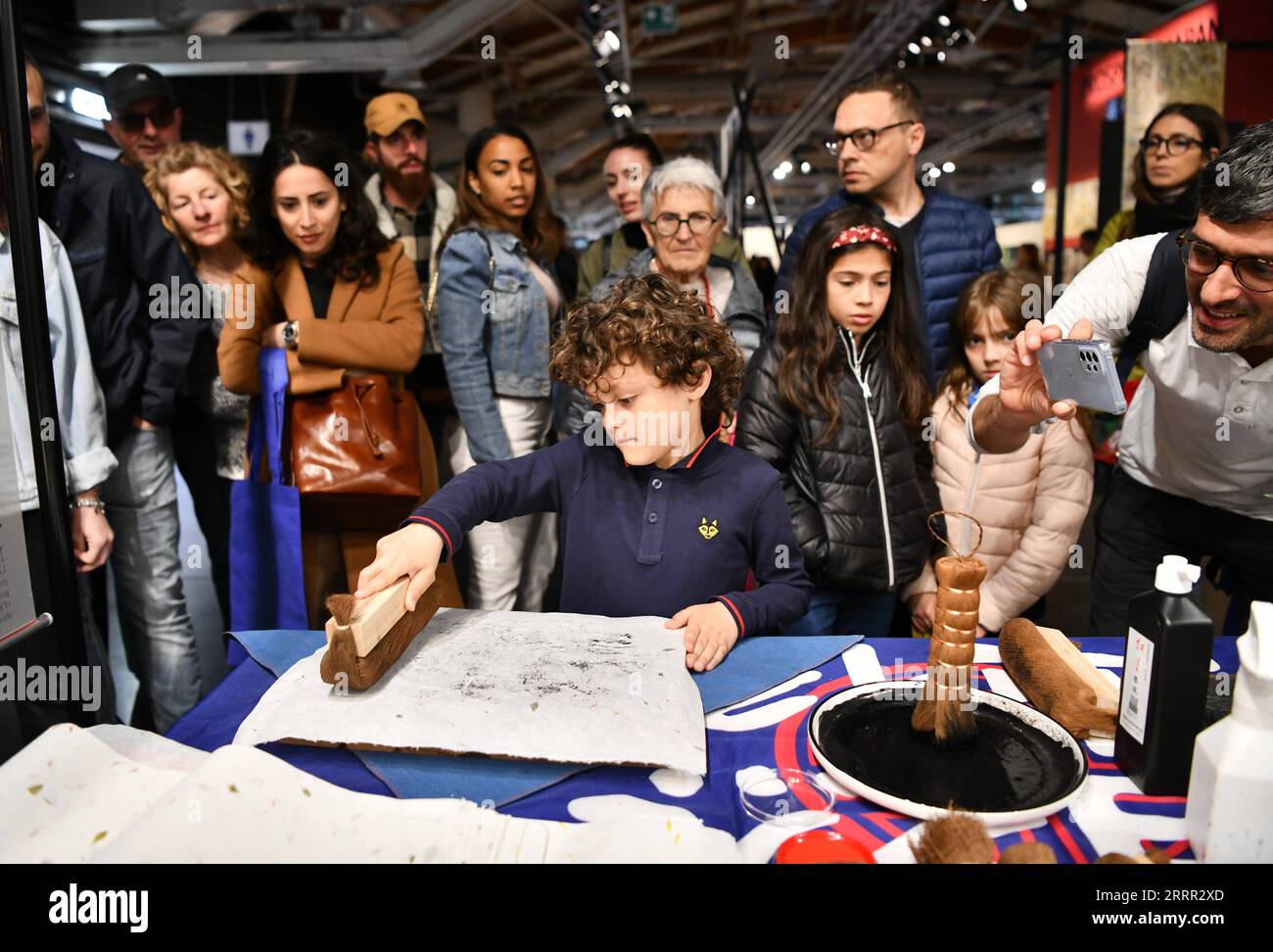 230428 -- FLORENZ, 28. April 2023 -- Ein Junge erlebt chinesischen Holzschnitt auf der 87. Internationalen Handwerksmesse in Florenz, Italien, am 25. April 2023. Die Messe findet vom 25. April bis 1. Mai statt und umfasst über 400 Aussteller aus aller Welt. ITALIEN-FLORENZ-INT L HANDWERK FAIR-CHINESISCHES HANDWERK JINXMAMENGNI PUBLICATIONXNOTXINXCHN Stockfoto