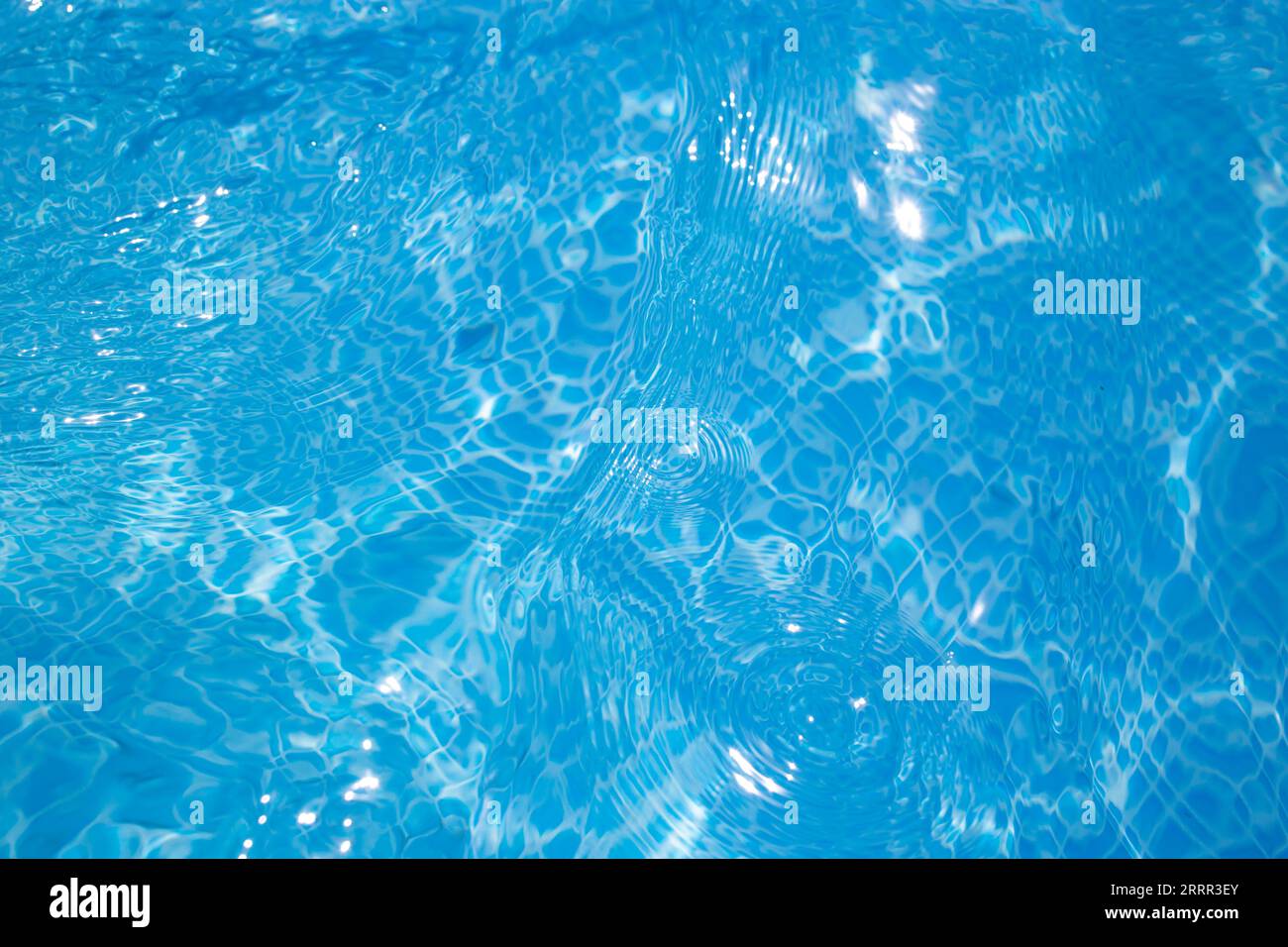 Das Wasser im Pool plätschert mit glitzernden Reflexionen des Sonnenlichts, Nahaufnahme Stockfoto