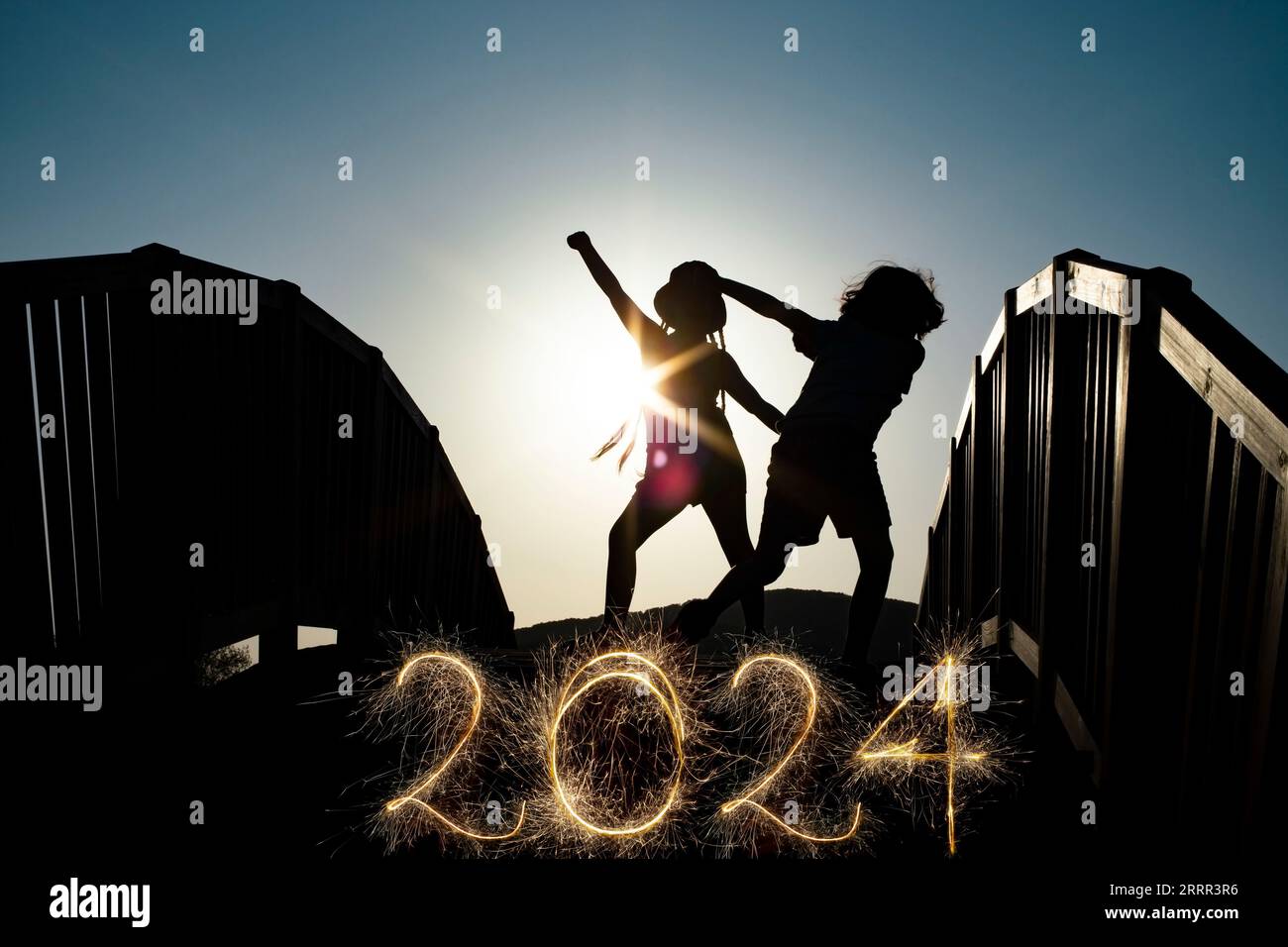 Nummer 2022 geschrieben funkelnde Glitzer, kreative Schablone für Feiertagsgrußkarte oder Poster für einen Partyjungen und Mädchen Silhouetten tanzen o Stockfoto